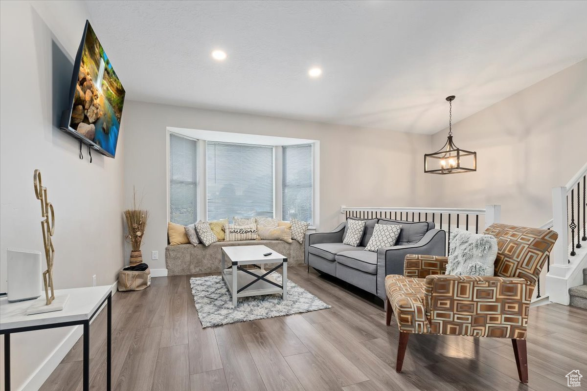 Living room with hardwood / wood-style flooring and an inviting chandelier