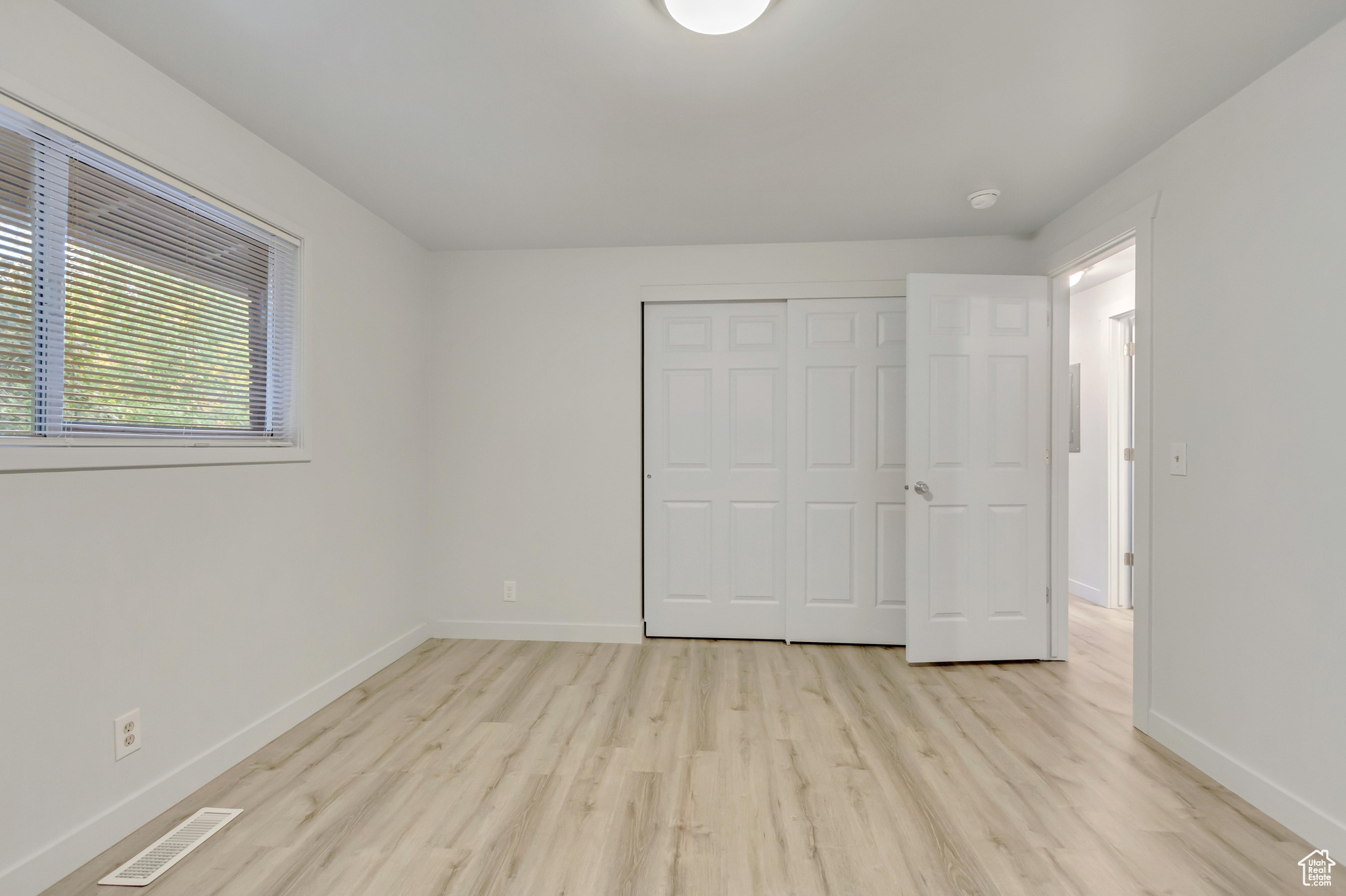 Unfurnished bedroom with light hardwood / wood-style floors and a closet