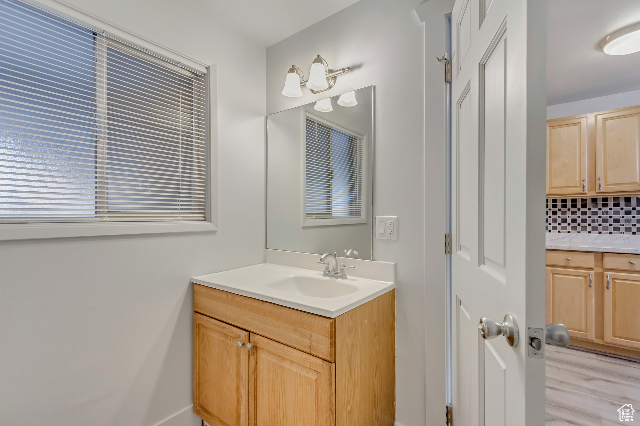 Bathroom with vanity, tasteful backsplash, and wood-type flooring