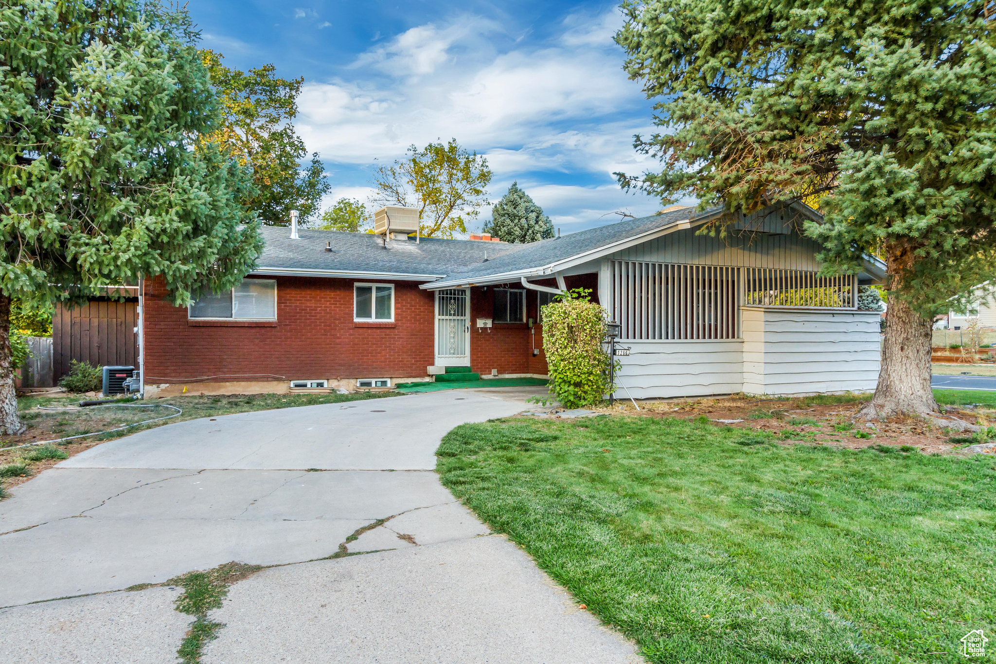 Ranch-style house with a front yard and central AC unit