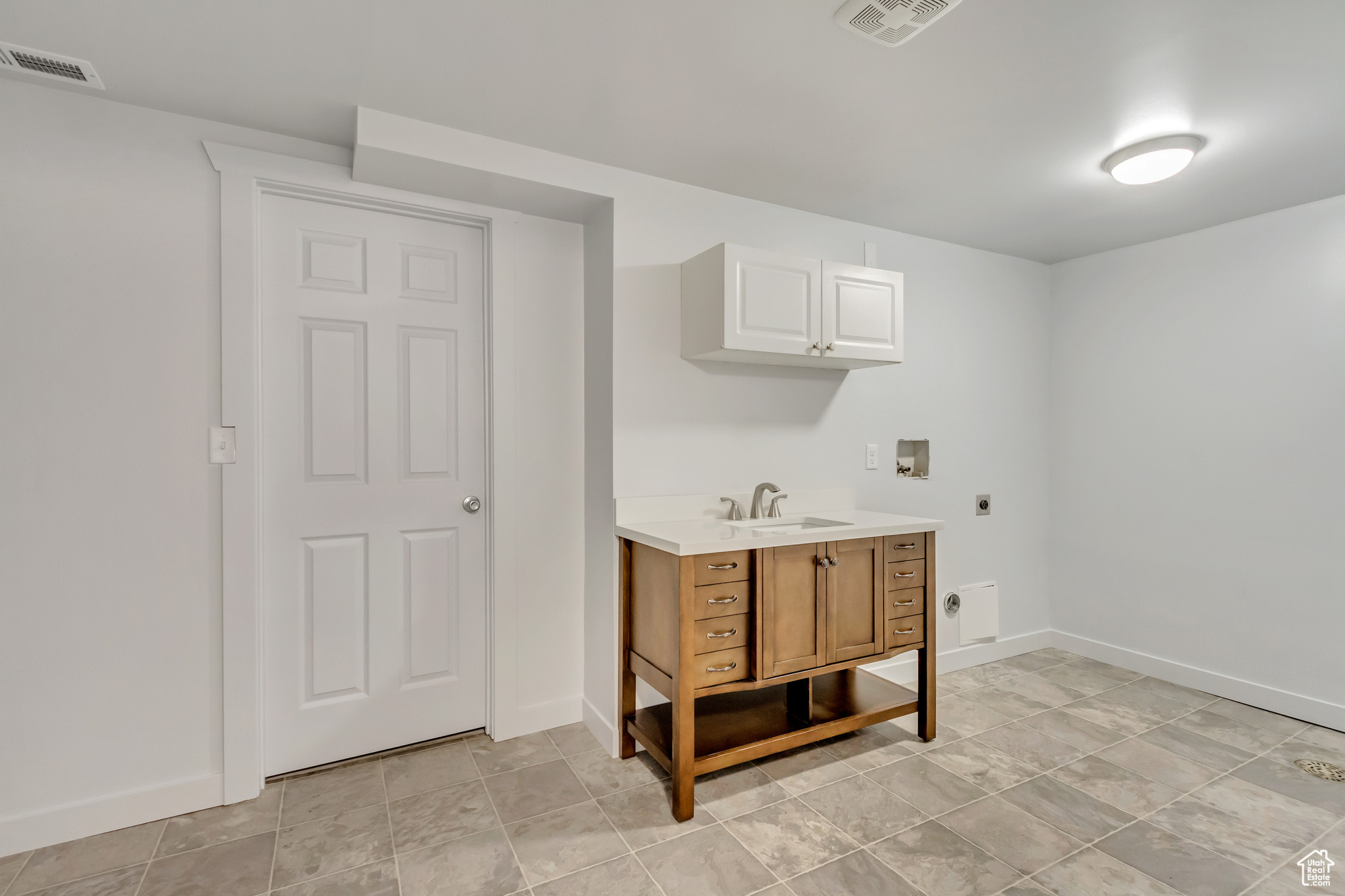 Clothes washing area featuring cabinets, hookup for a washing machine, sink, and electric dryer hookup