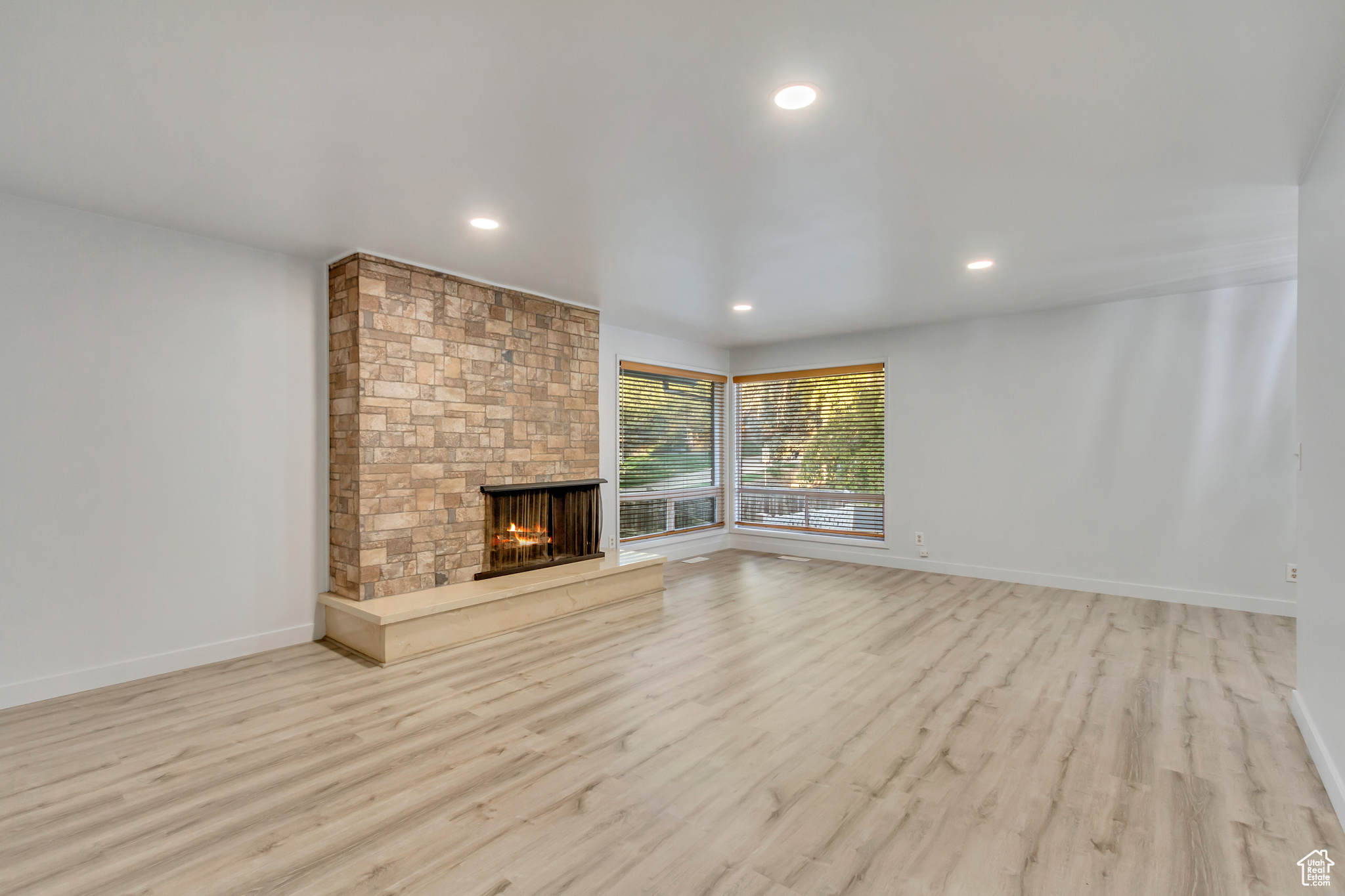 Unfurnished living room with a fireplace and light wood-type flooring