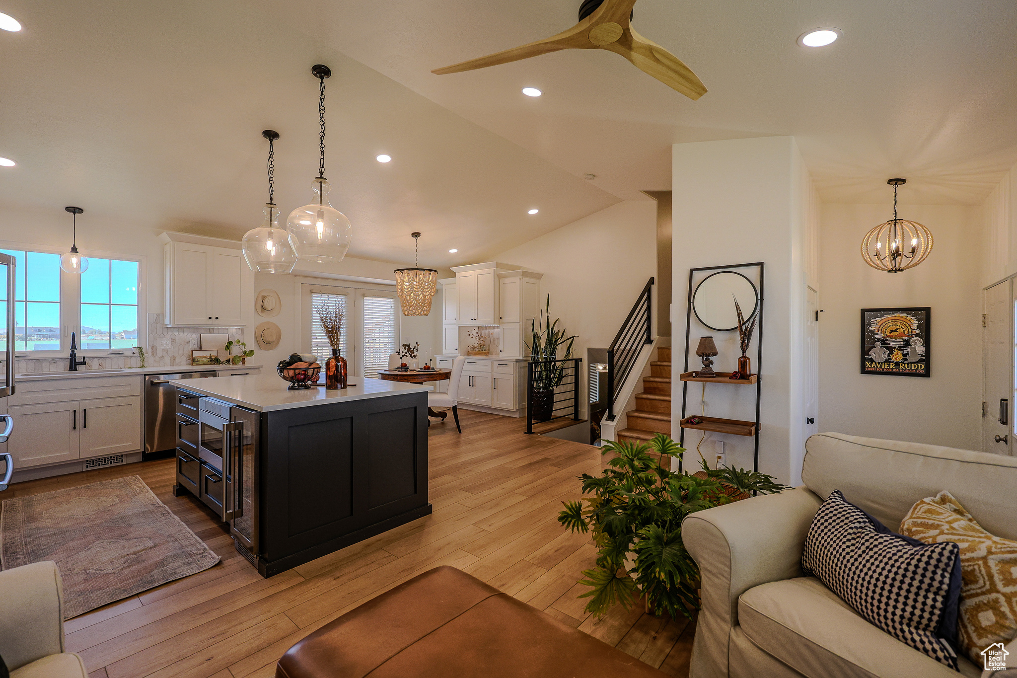 Kitchen featuring white cabinetry, a healthy amount of sunlight, decorative light fixtures, and a kitchen island