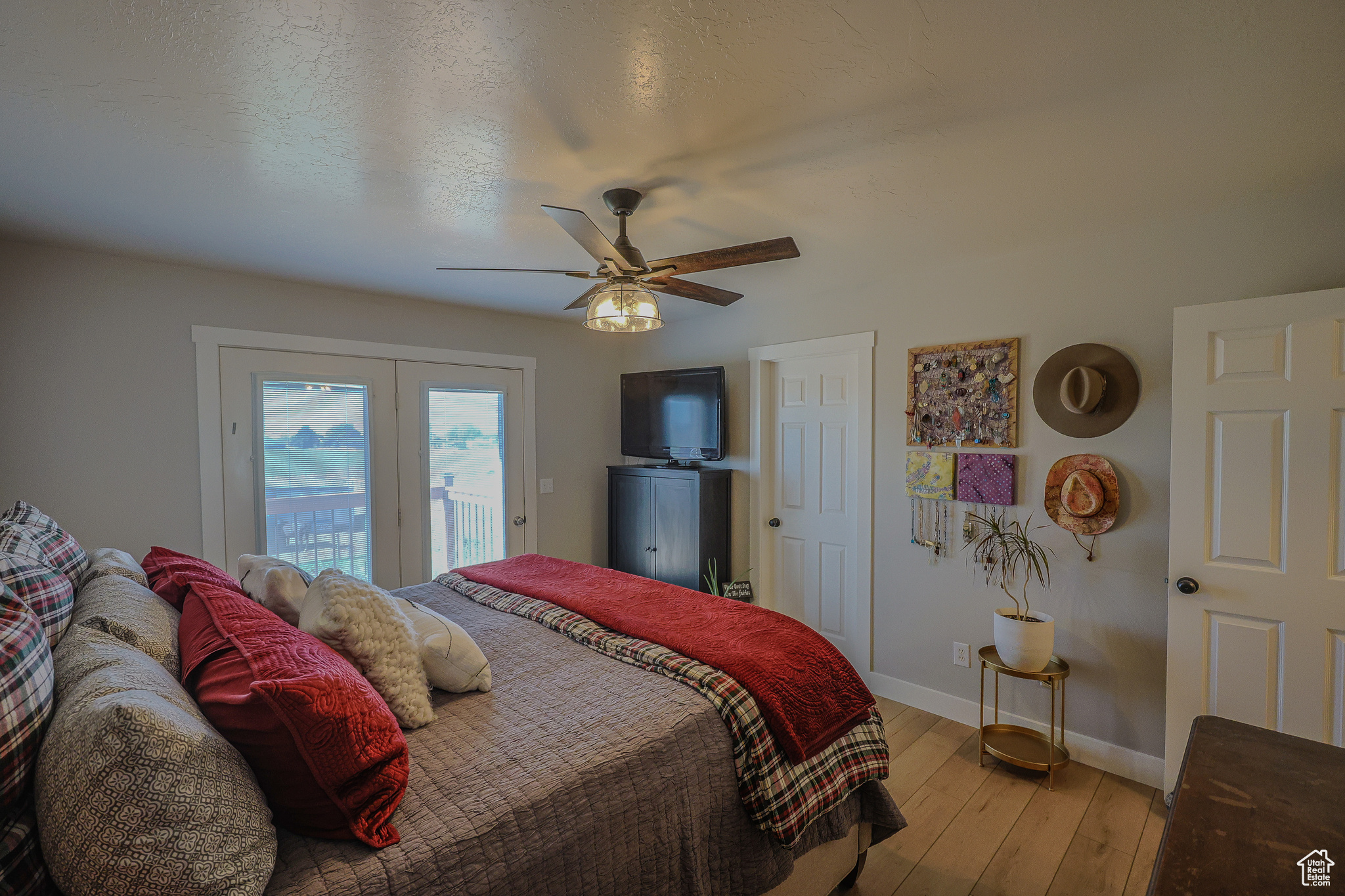 Bedroom featuring light hardwood / wood-style flooring, a textured ceiling, access to outside, and ceiling fan