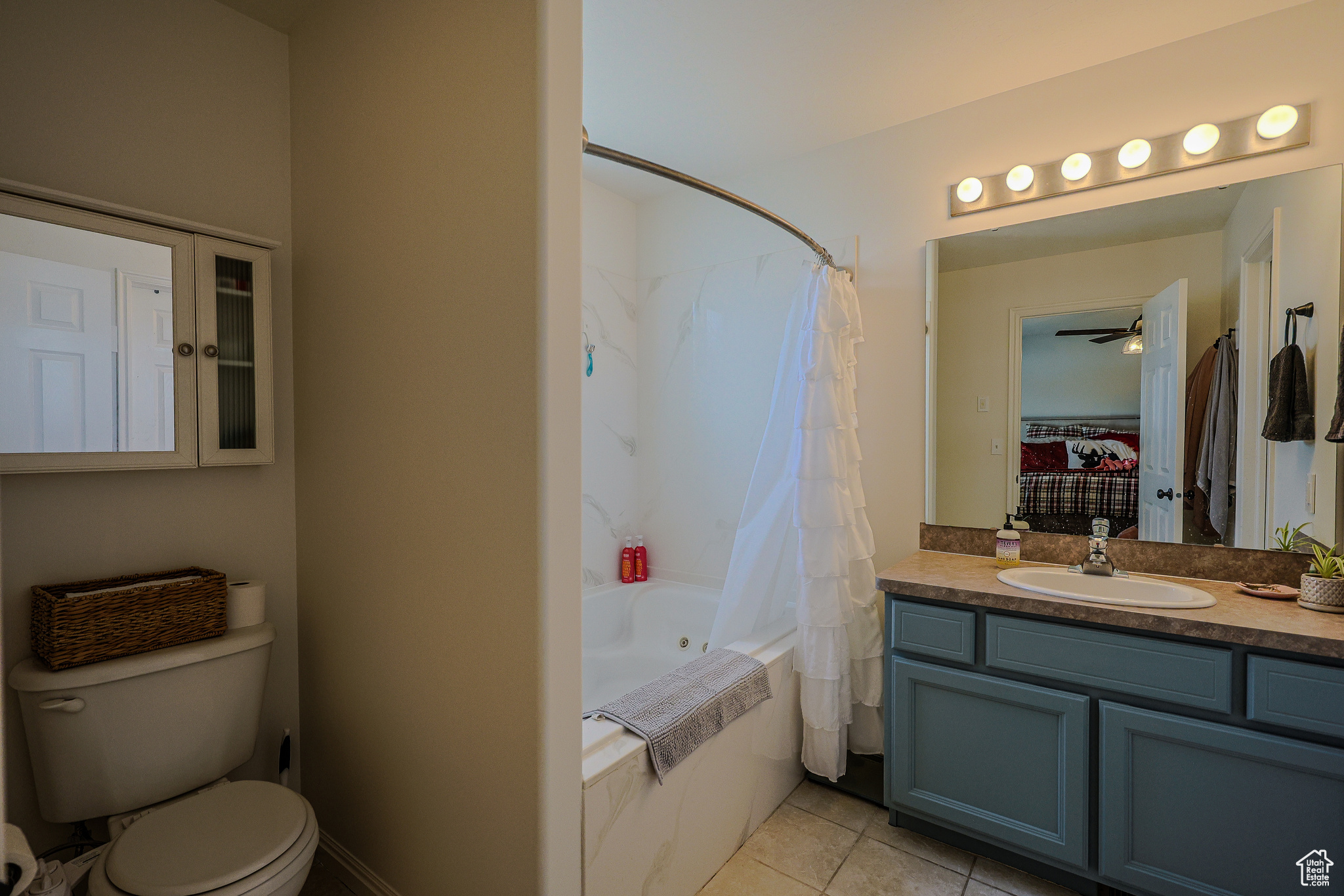 Full bathroom featuring shower / bath combination with curtain, toilet, tile patterned flooring, and vanity