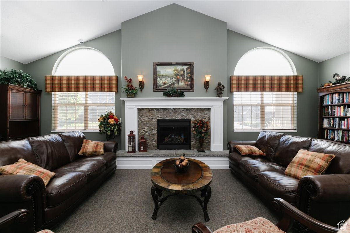 Carpeted living room with lofted ceiling