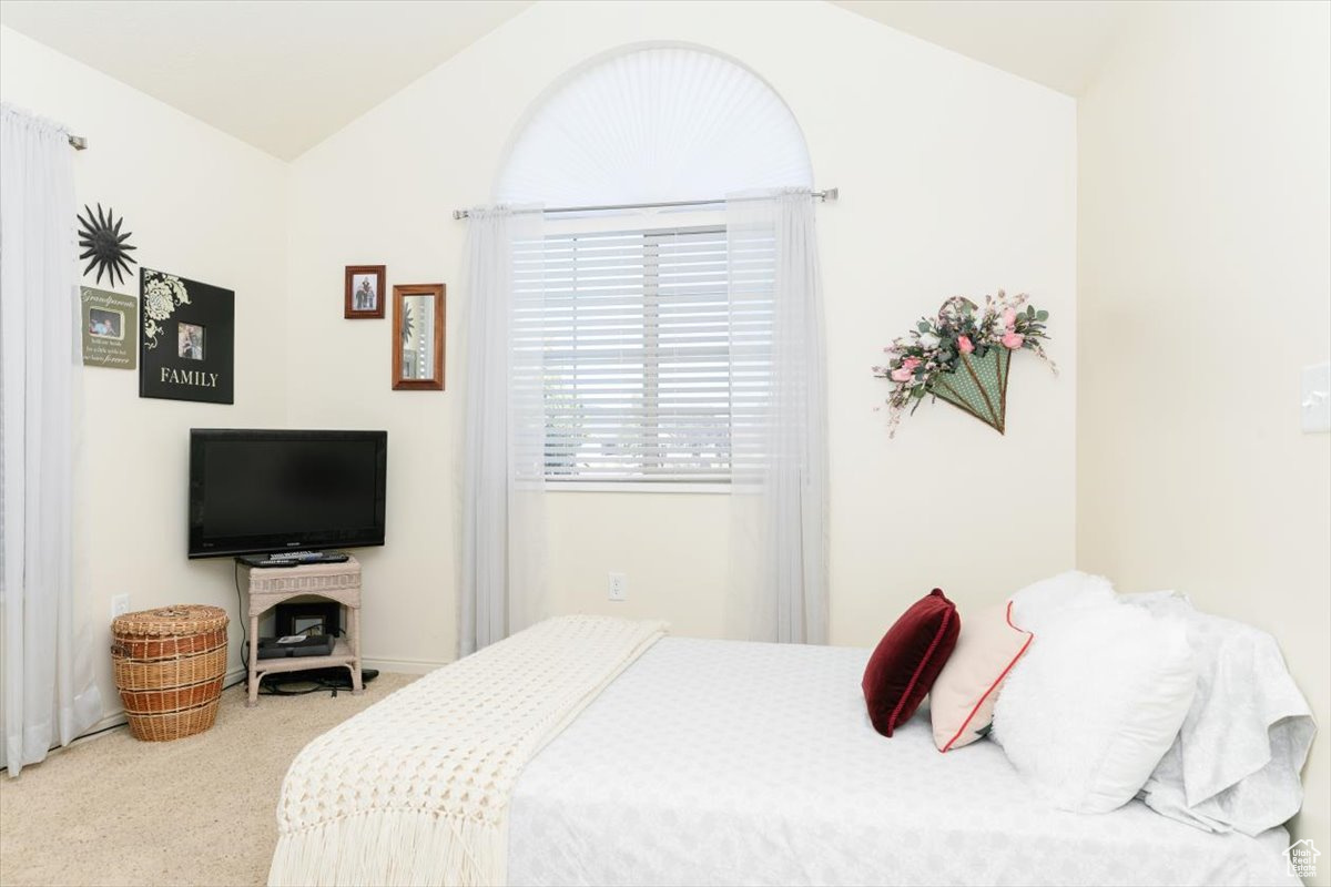 Bedroom with carpet and vaulted ceiling