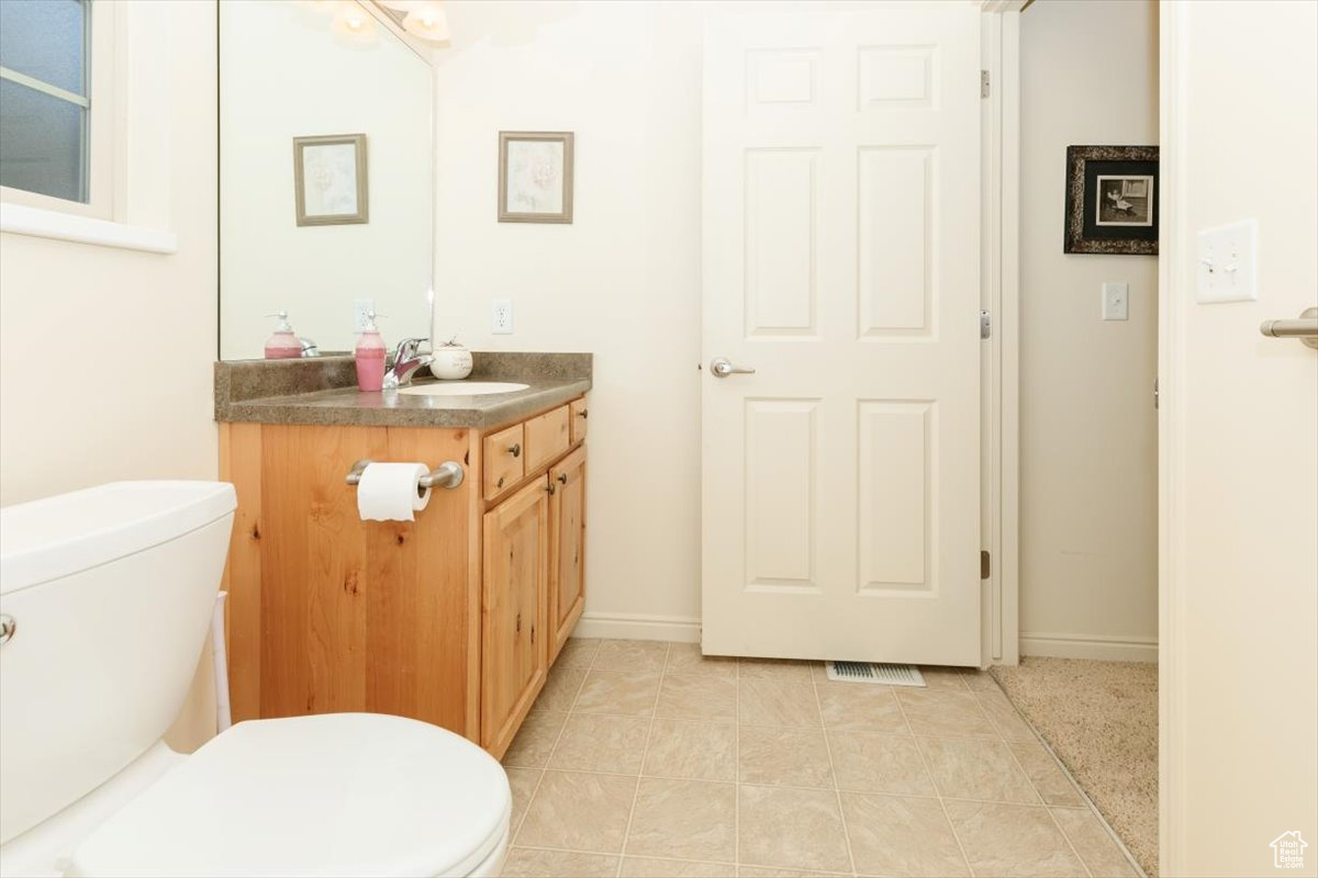 Bathroom featuring vanity, toilet, and tile patterned floors