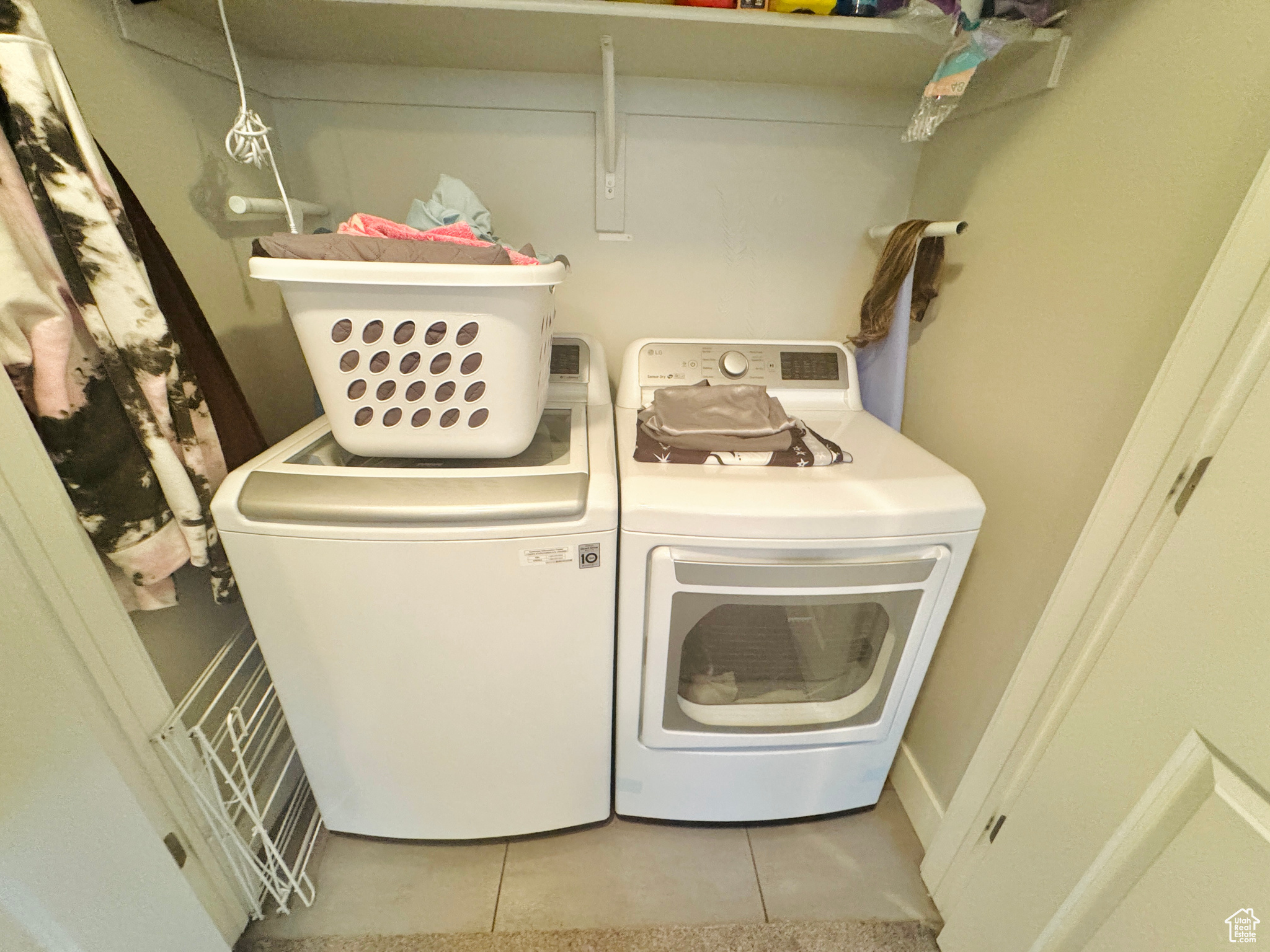 Laundry room featuring washing machine and dryer and light tile patterned floors