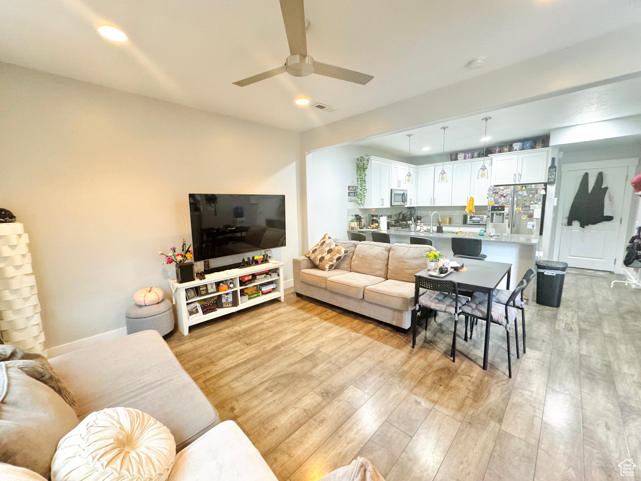 Living room with light hardwood / wood-style floors, sink, and ceiling fan