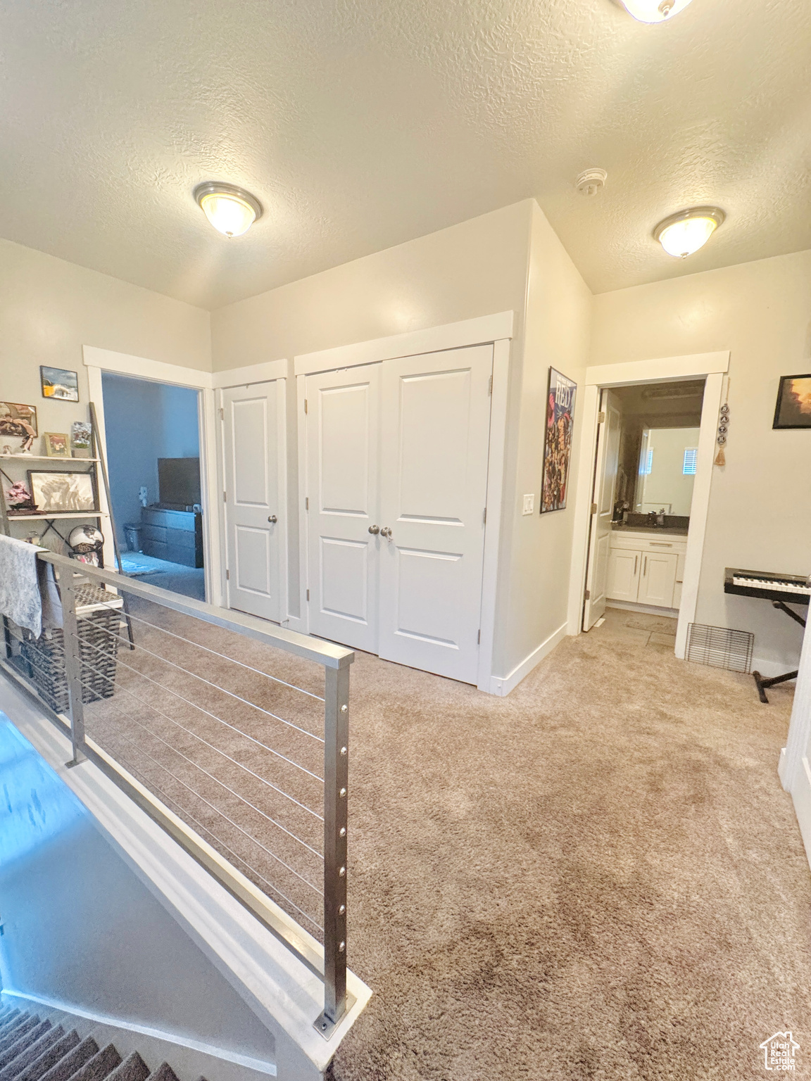 Bedroom featuring light carpet and a textured ceiling