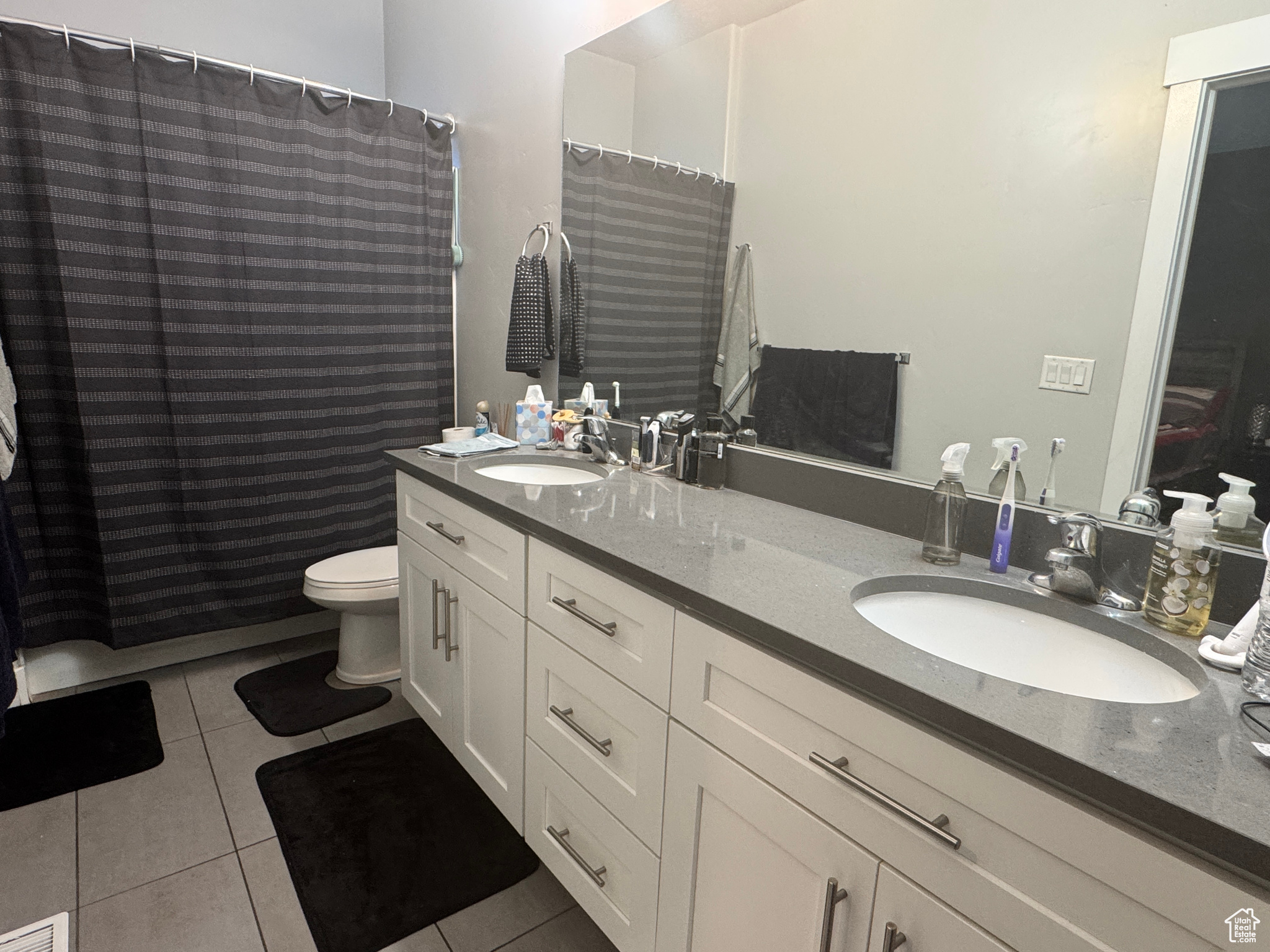 Bathroom featuring vanity, toilet, tile patterned floors, and a shower with shower curtain