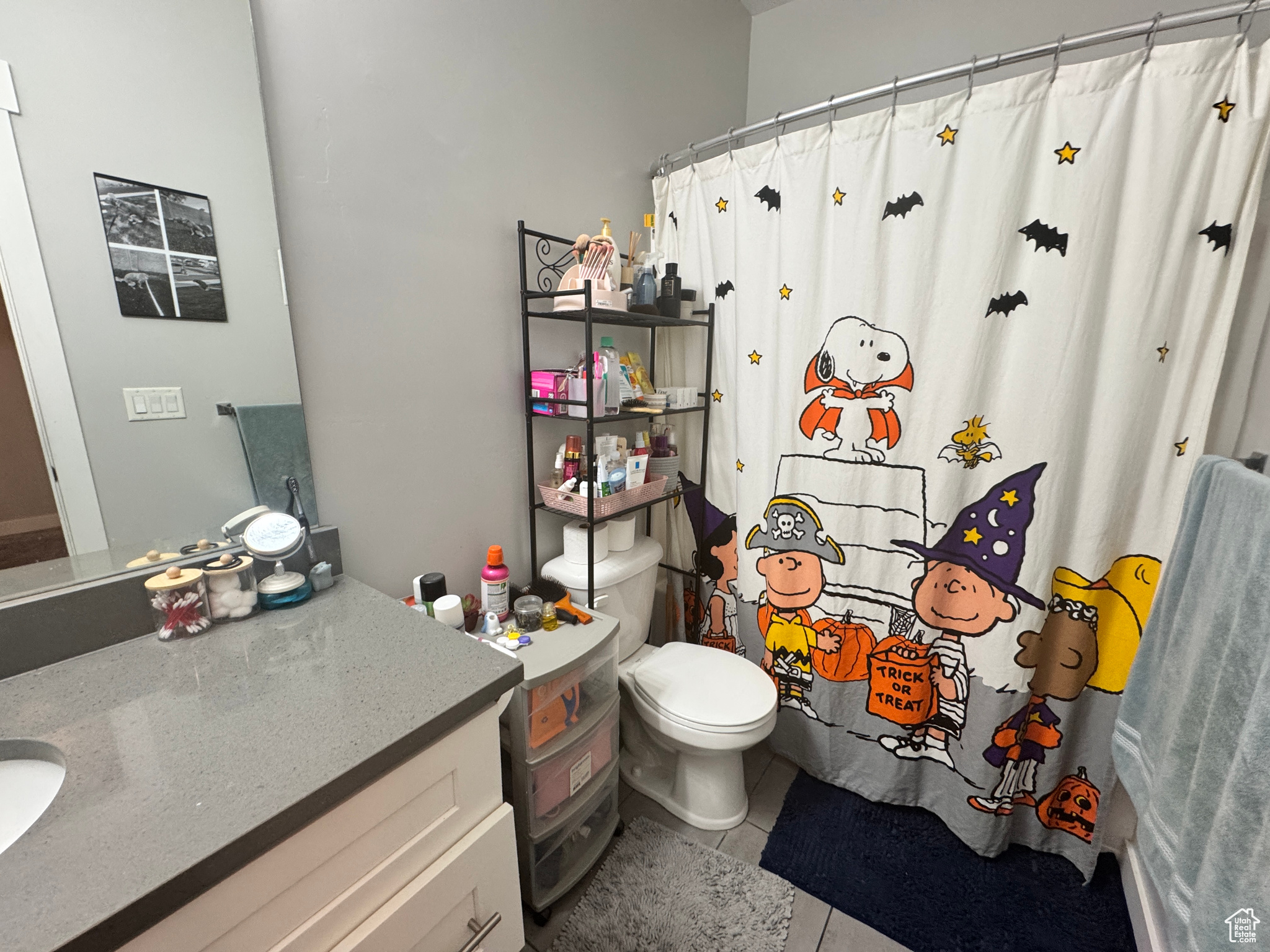 Bathroom featuring vanity, curtained shower, toilet, and tile patterned floors