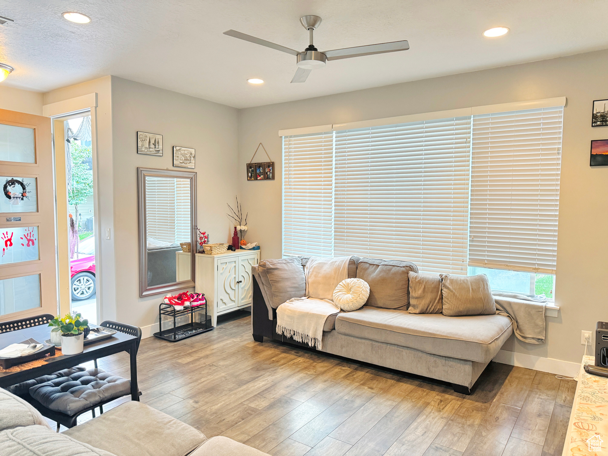 Living room with ceiling fan, light hardwood / wood-style flooring, and plenty of natural light