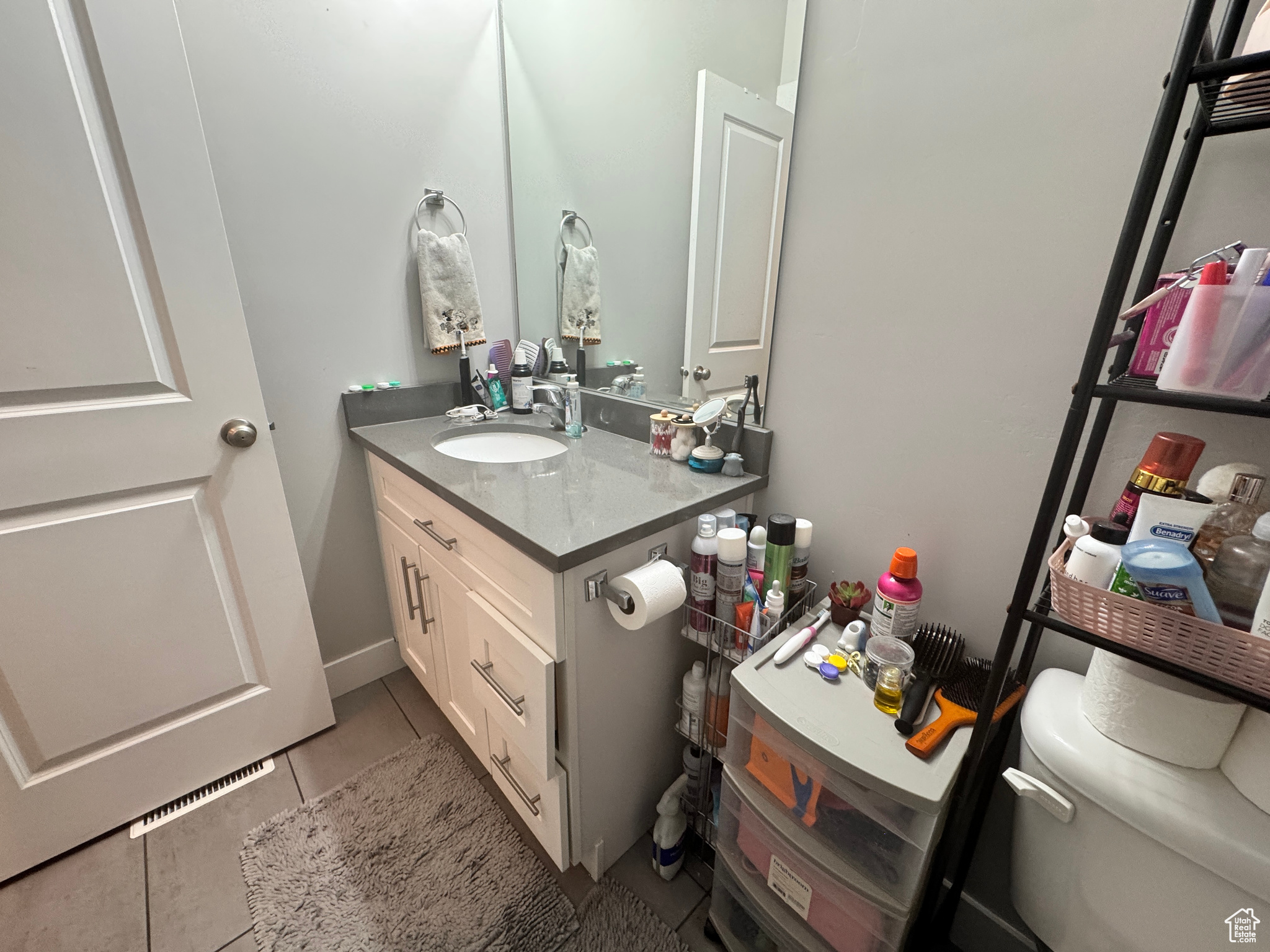 Bathroom featuring vanity, toilet, and tile patterned flooring