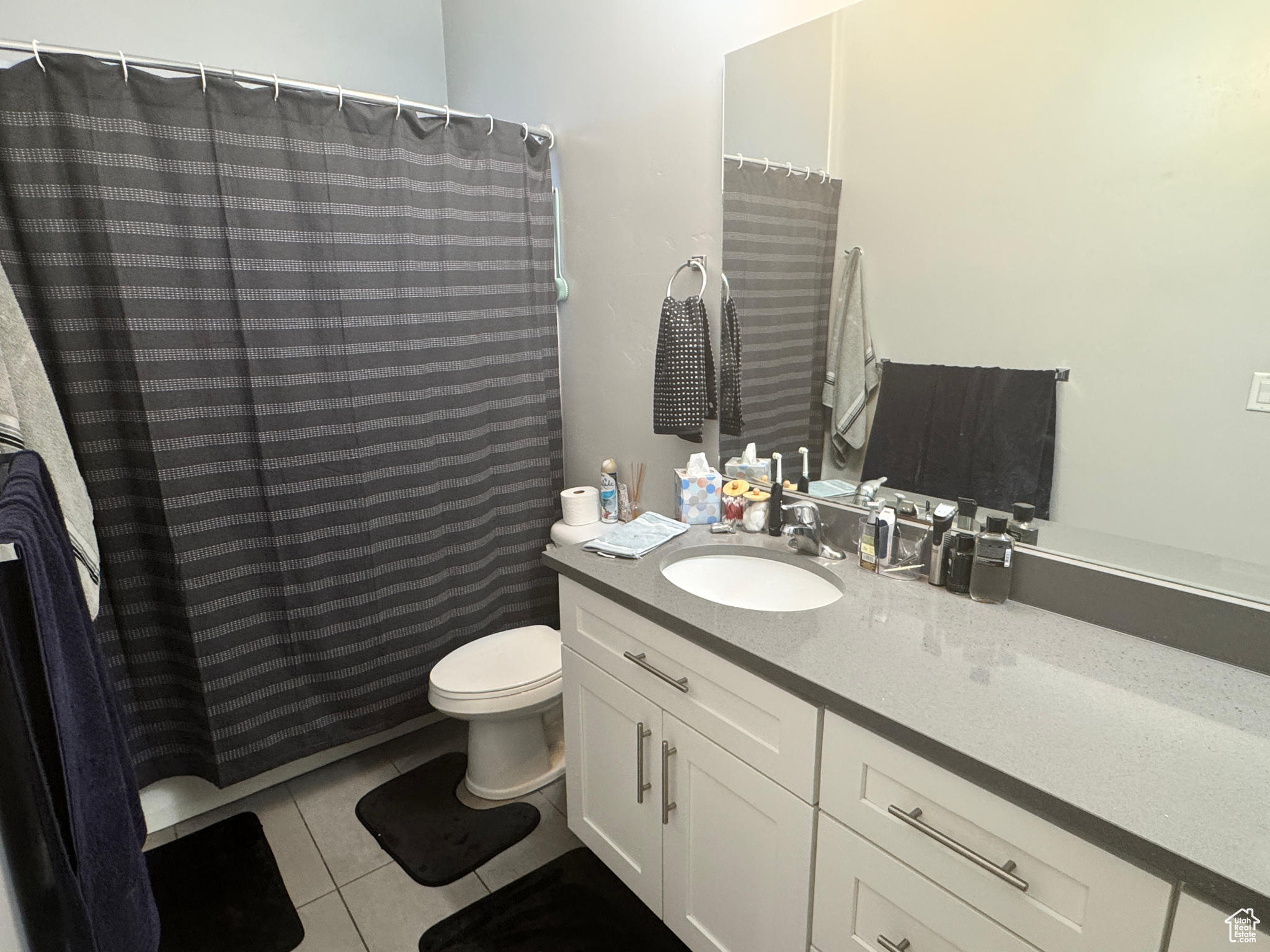 Bathroom with vanity, toilet, a shower with shower curtain, and tile patterned flooring