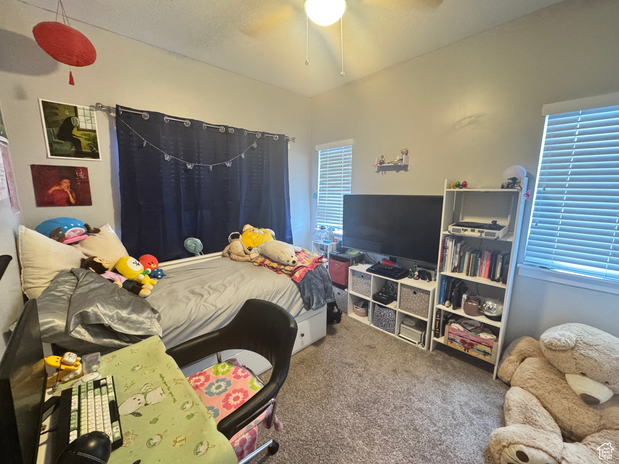 Bedroom featuring multiple windows, carpet floors, and ceiling fan