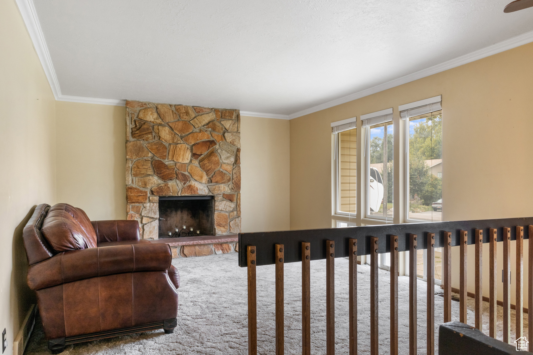 Living room with crown molding and a fireplace