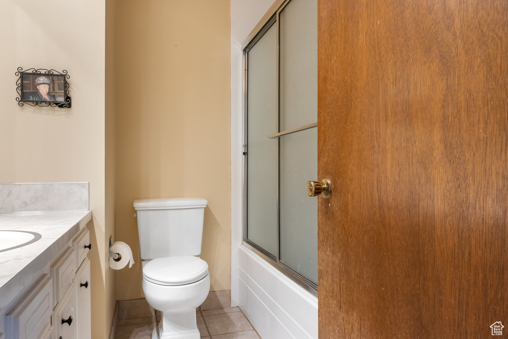 Full bathroom featuring vanity, shower / bath combination with glass door, toilet, and tile patterned flooring