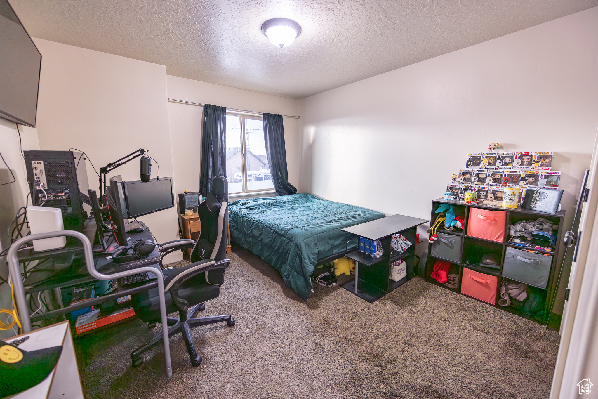 Bedroom with a textured ceiling and carpet flooring