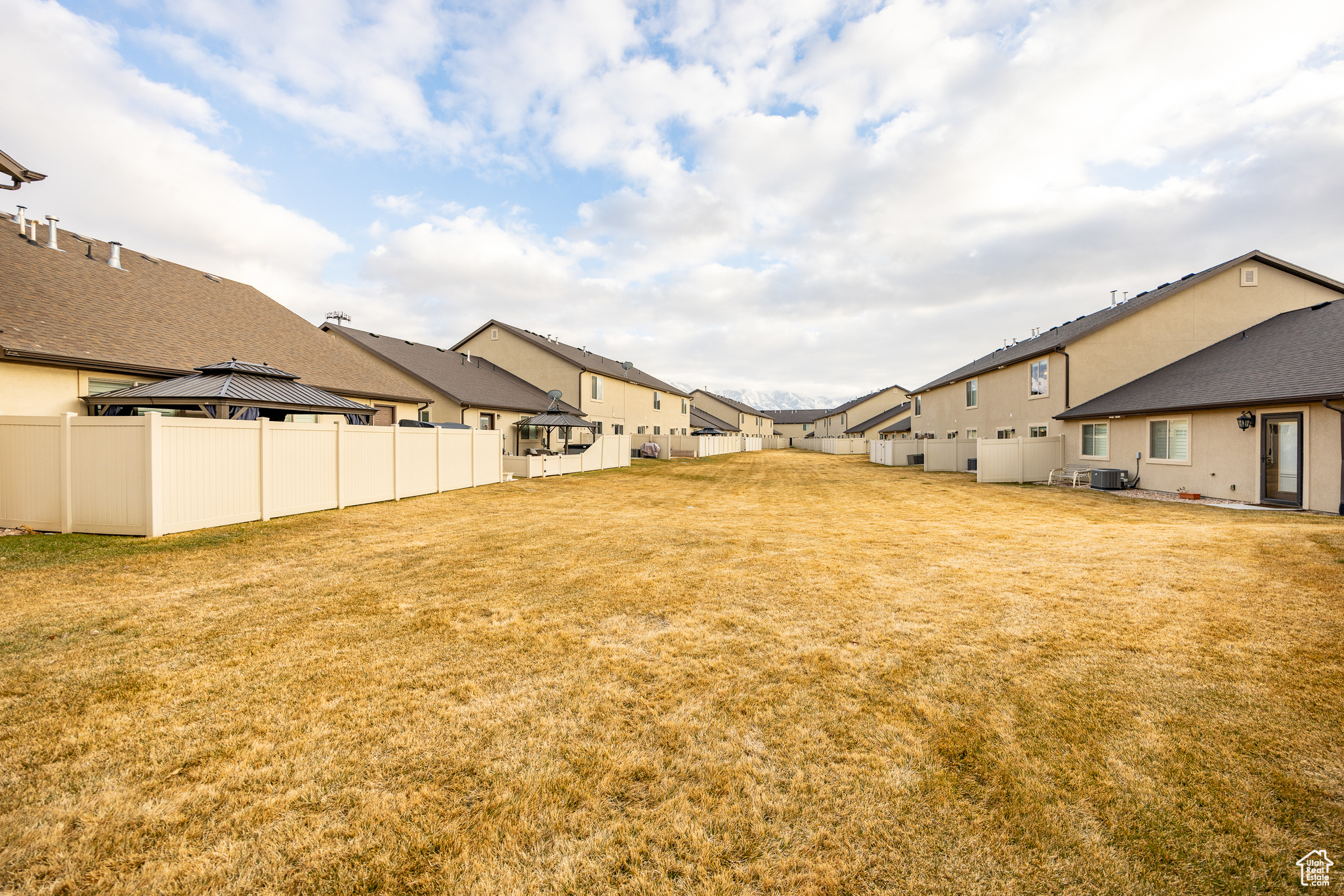 View of yard featuring a gazebo, fence, a residential view, and central air condition unit