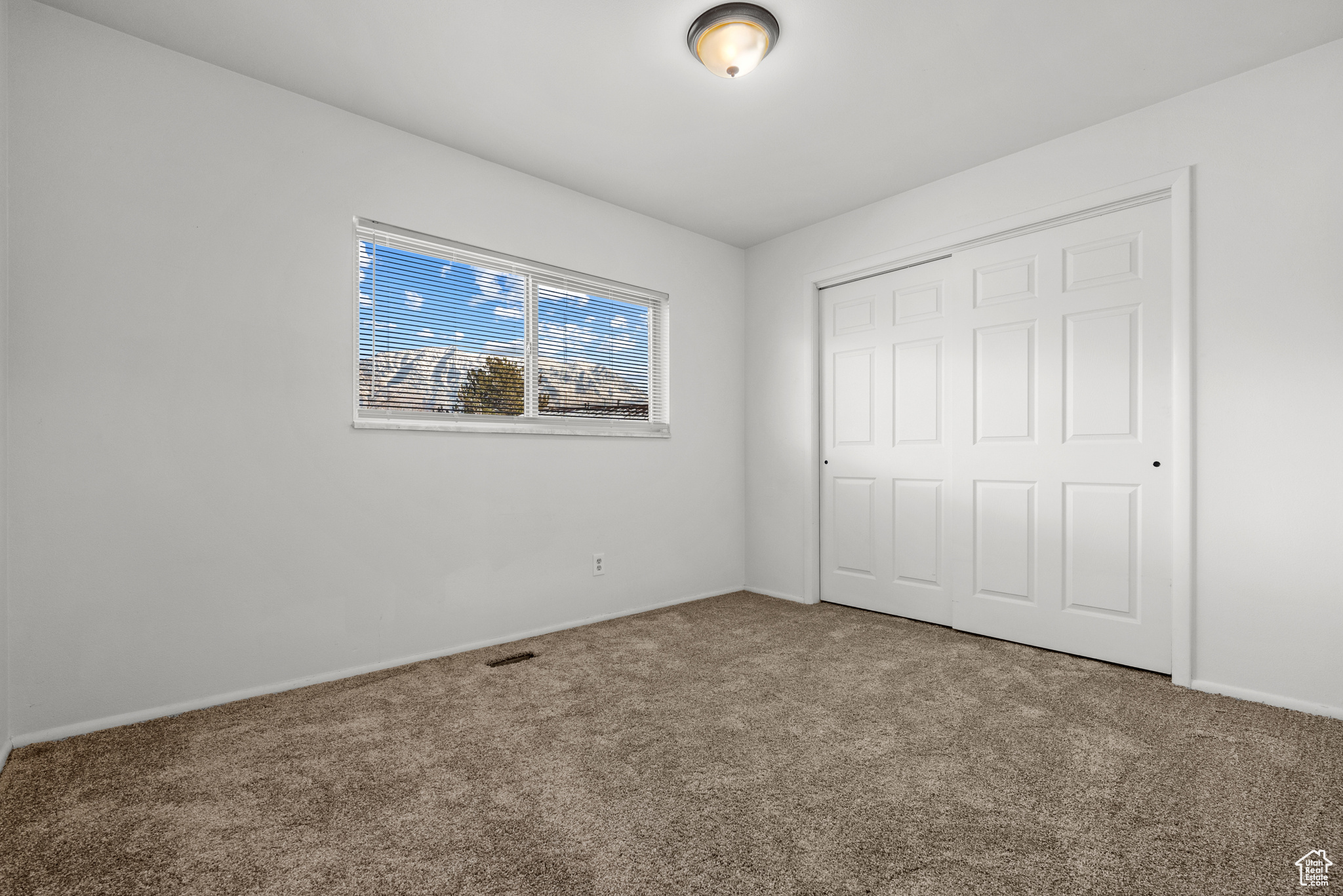 Unfurnished bedroom with carpet and a closet