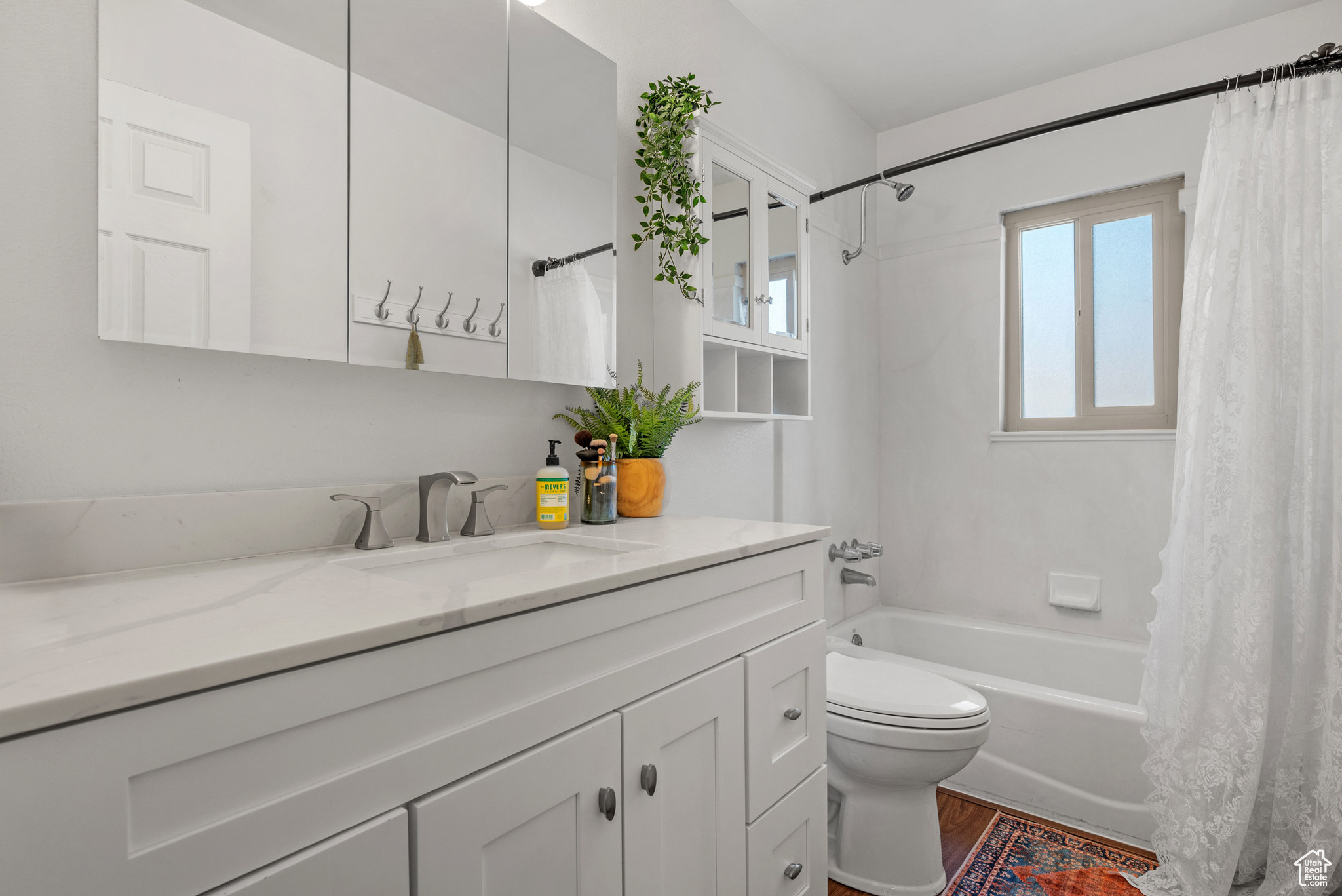 Full bathroom featuring vanity, wood-type flooring, toilet, and shower / bath combo with shower curtain