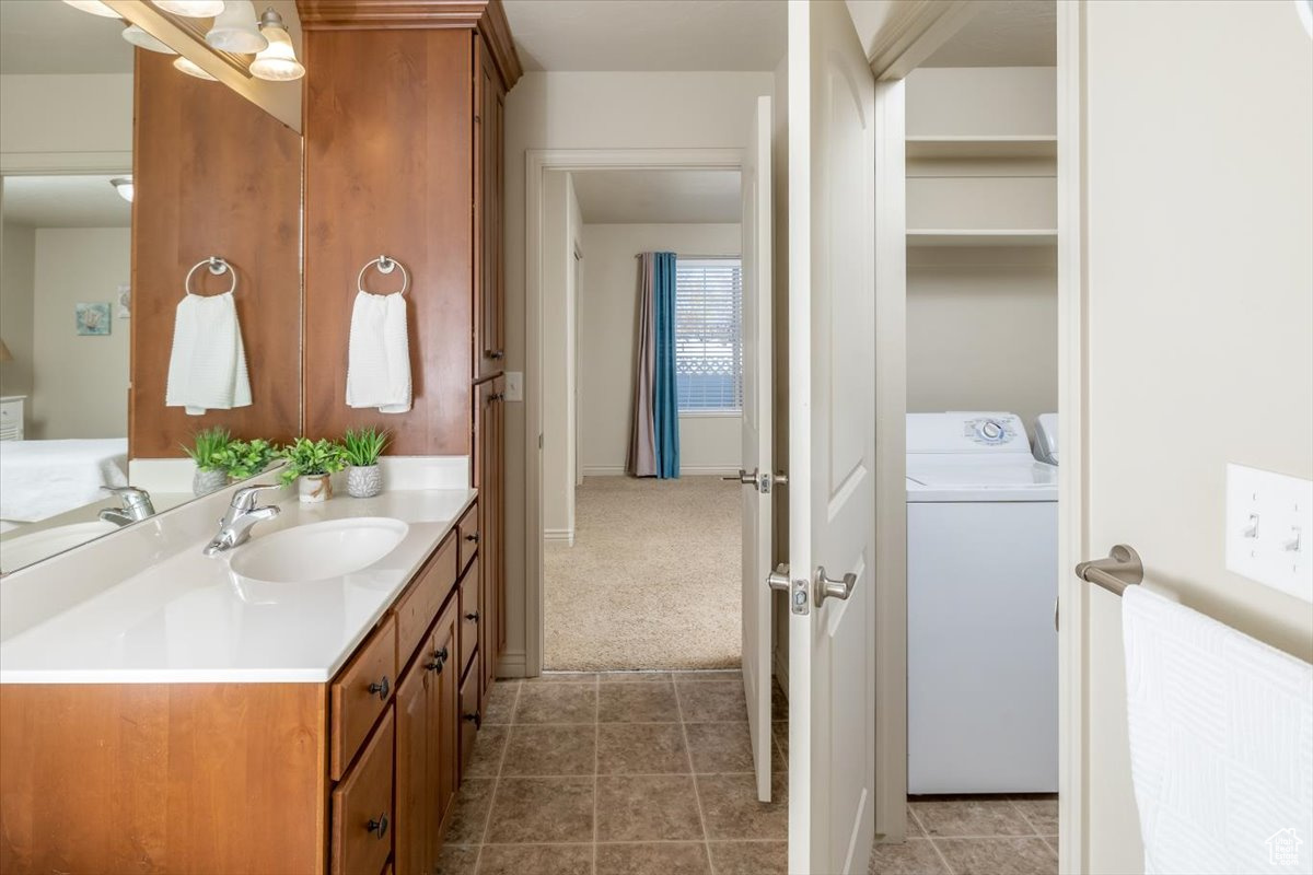 Bathroom featuring washer / dryer, vanity, and tile patterned flooring