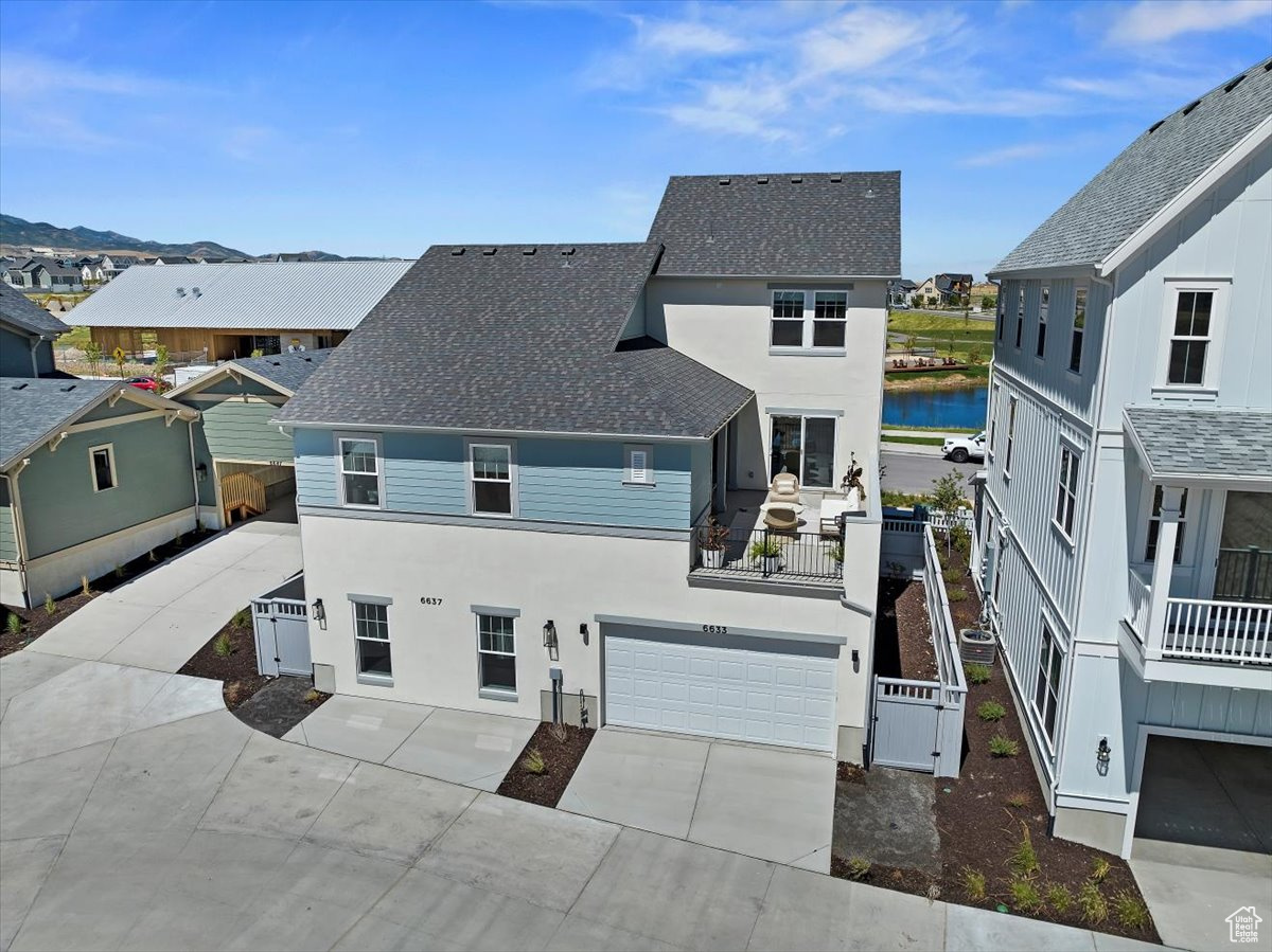 View of front of property with a water view and a garage