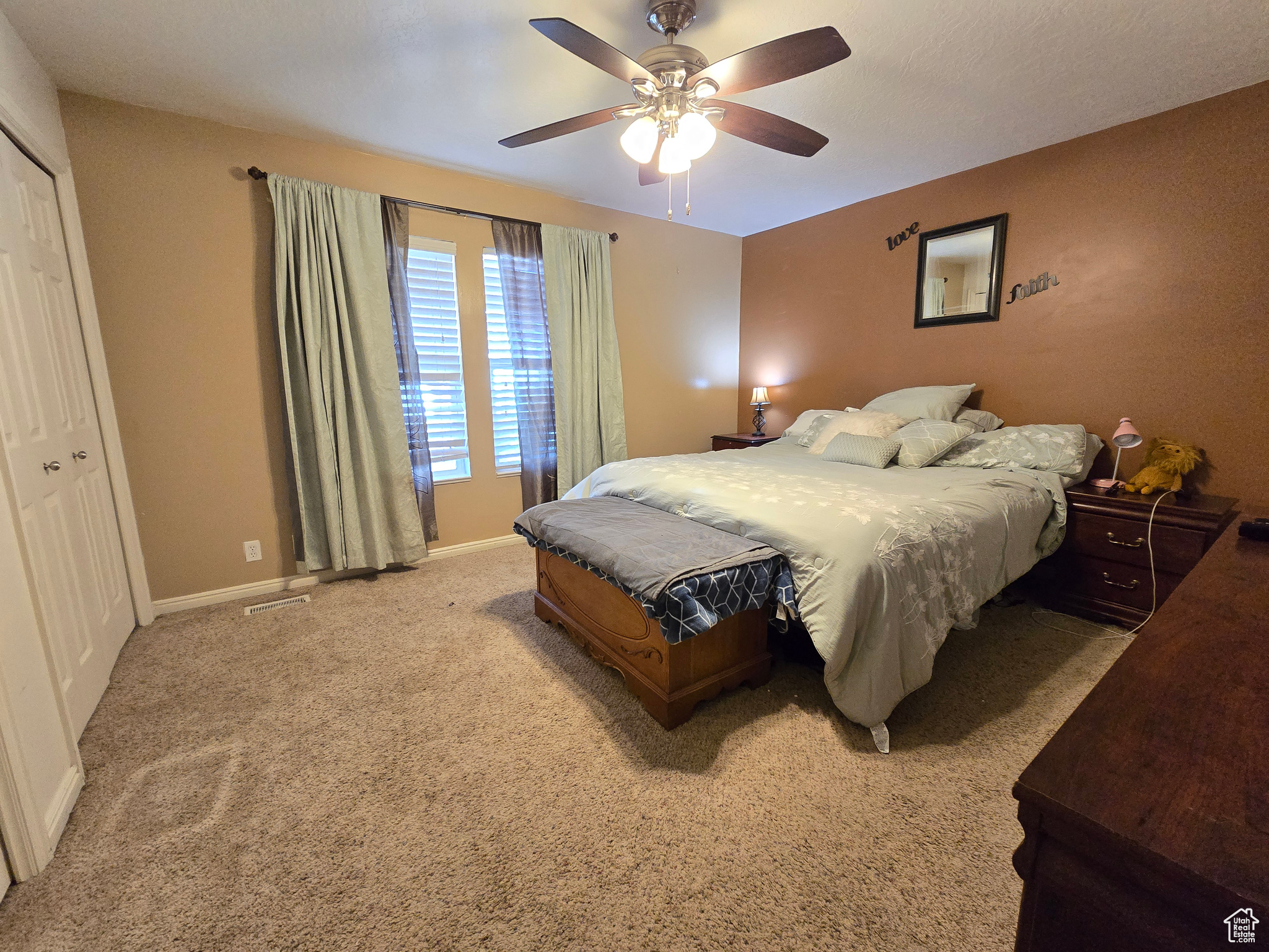 Carpeted bedroom featuring a closet and ceiling fan