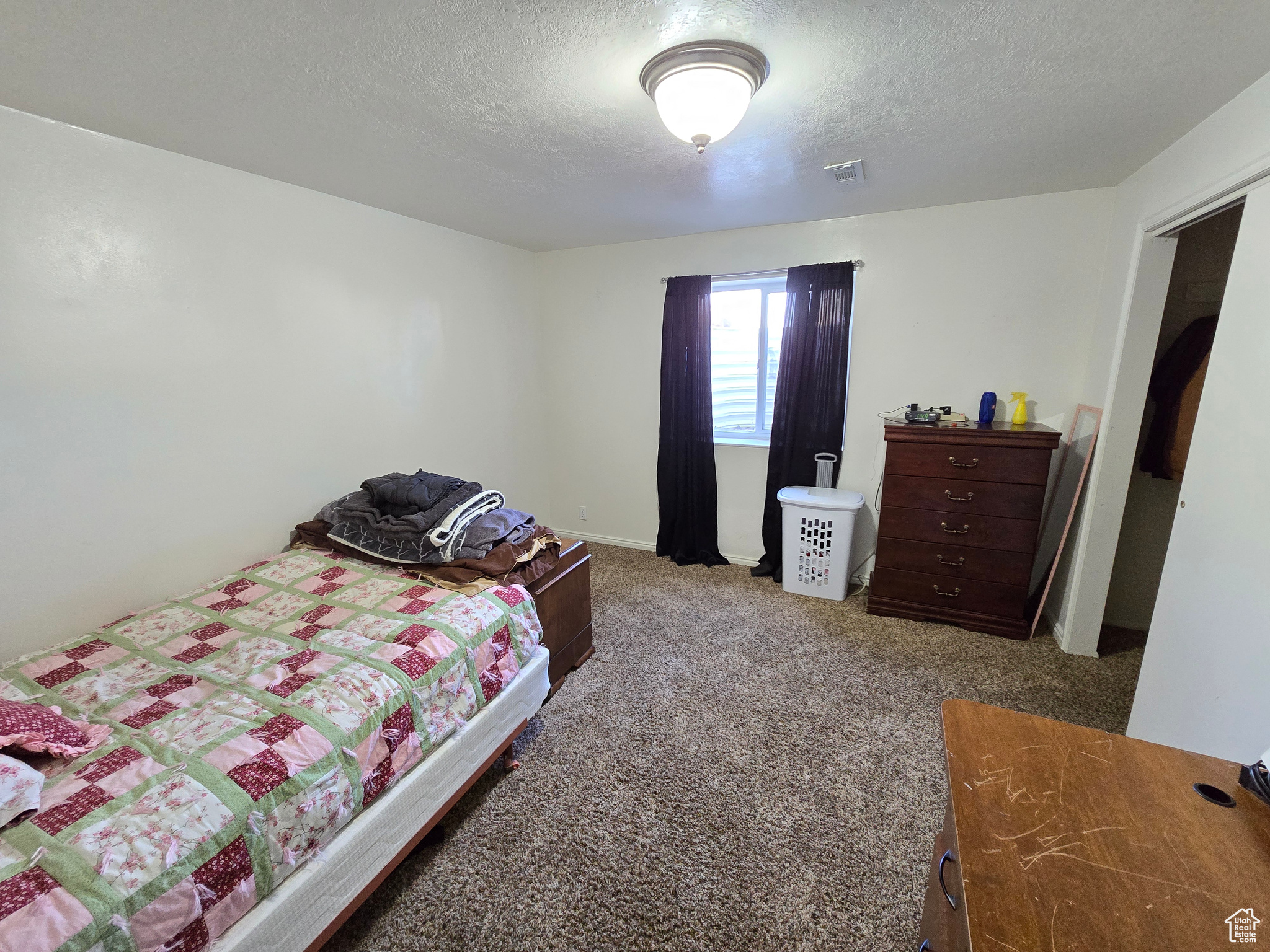 Bedroom featuring a textured ceiling and carpet