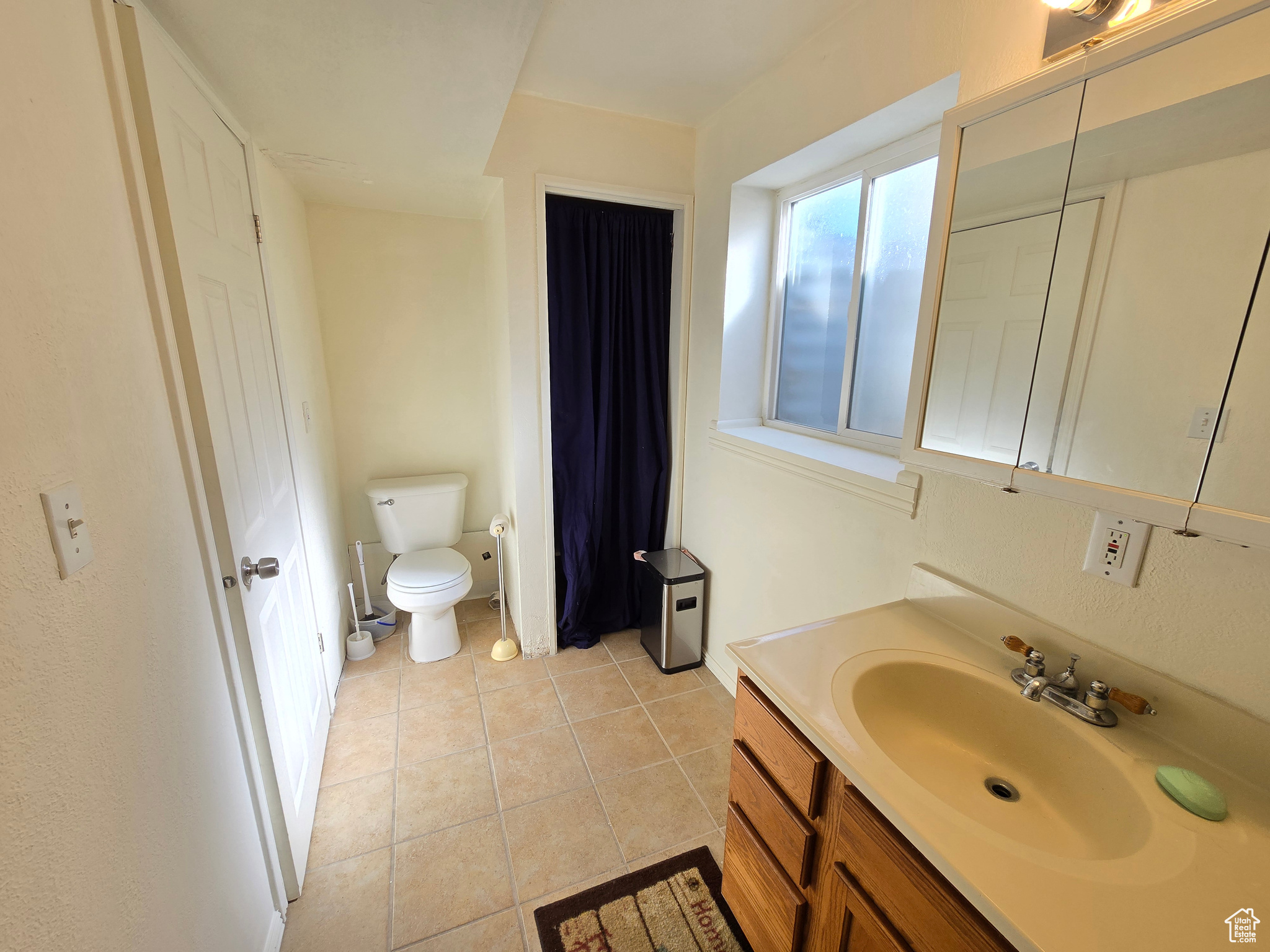 Bathroom featuring toilet, vanity, and tile patterned flooring