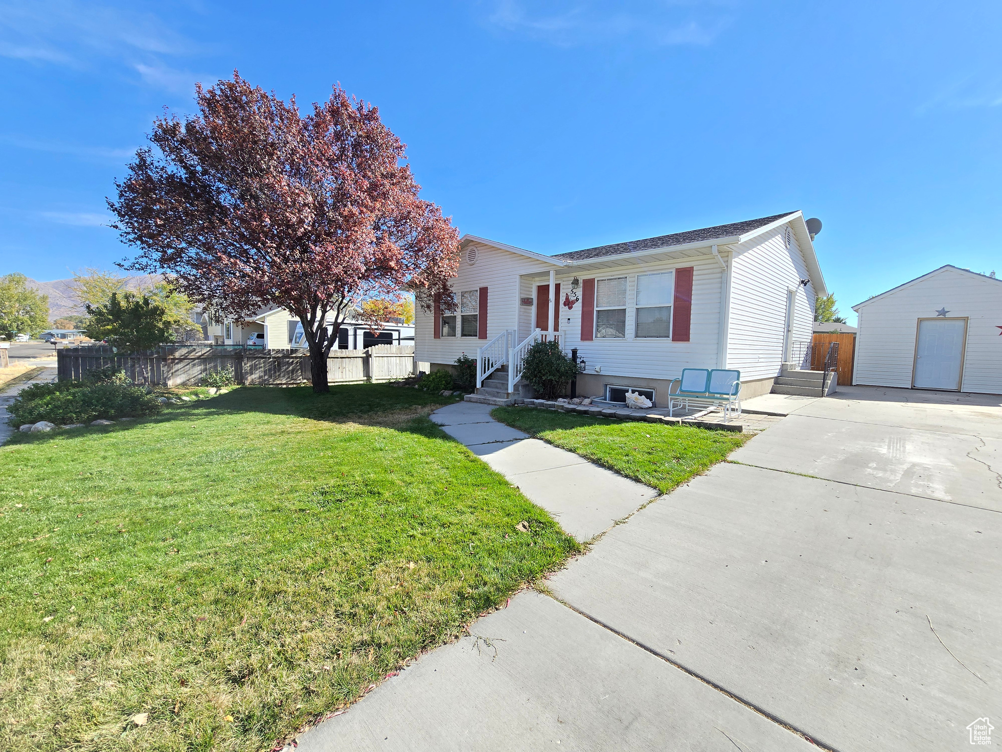 View of front of home featuring a front yard, an outbuilding, and a garage