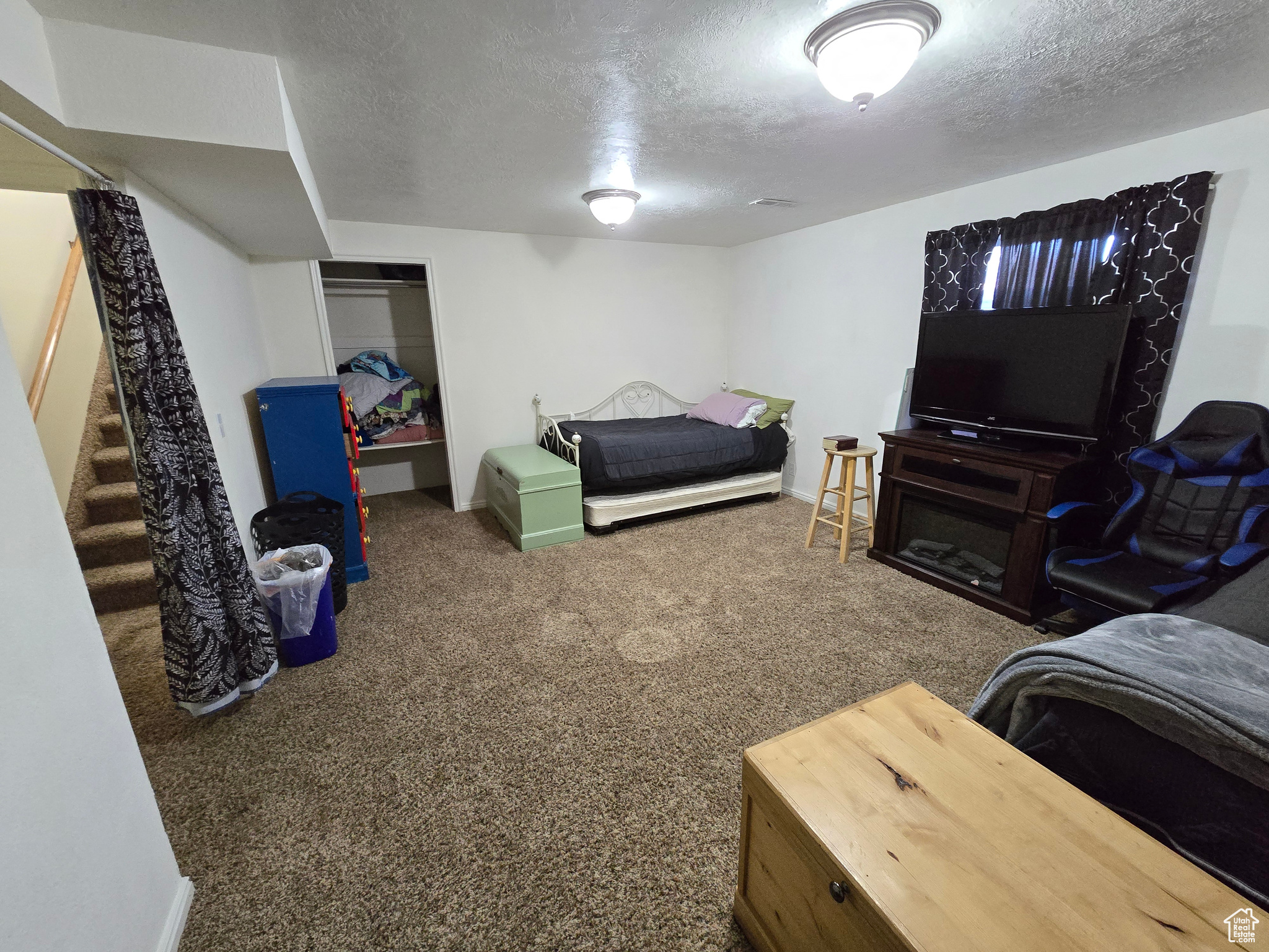 Bedroom with a textured ceiling and dark carpet