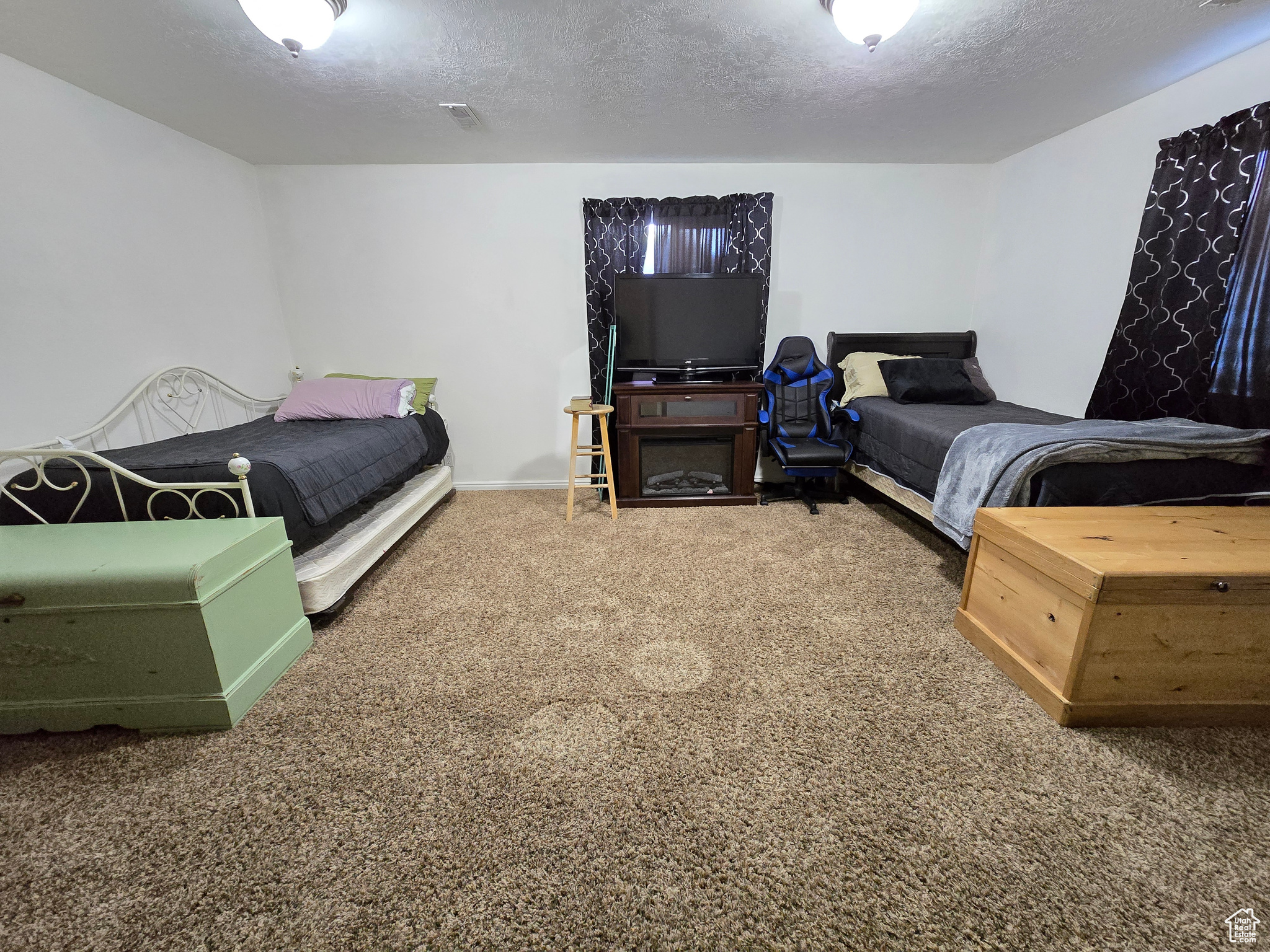 Carpeted bedroom with a textured ceiling