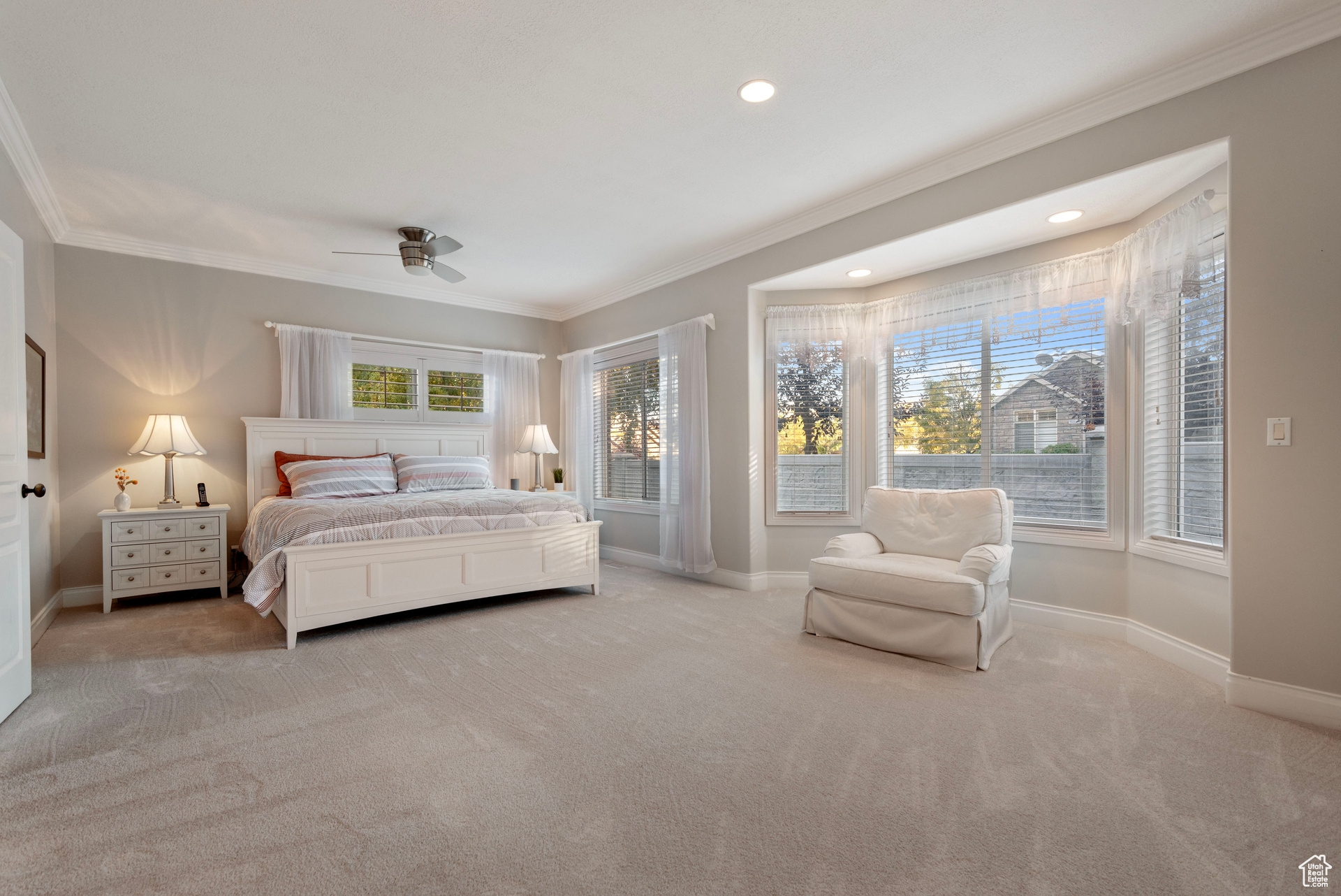 Bedroom featuring crown molding, light colored carpet, and ceiling fan