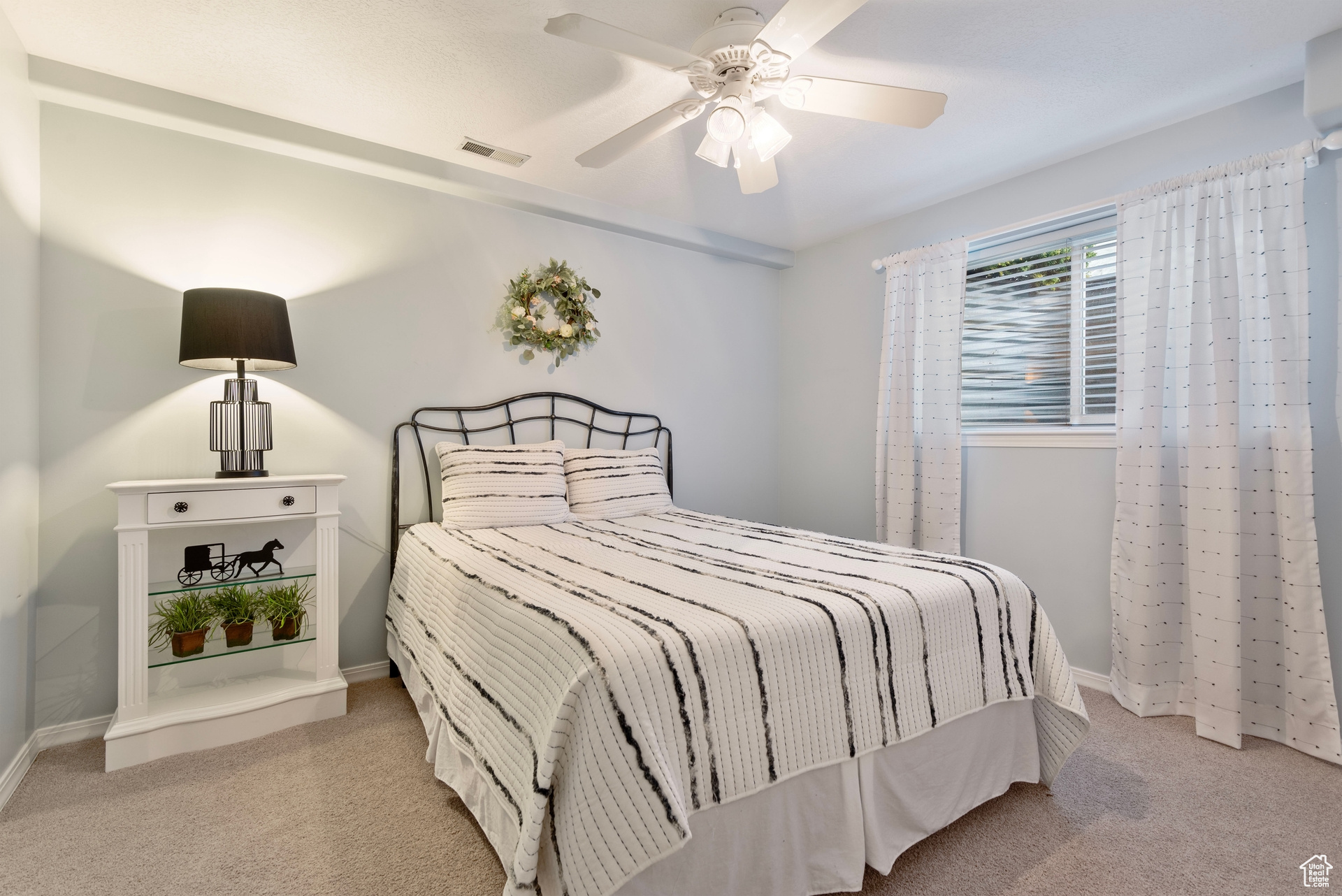 Bedroom with ceiling fan and light carpet