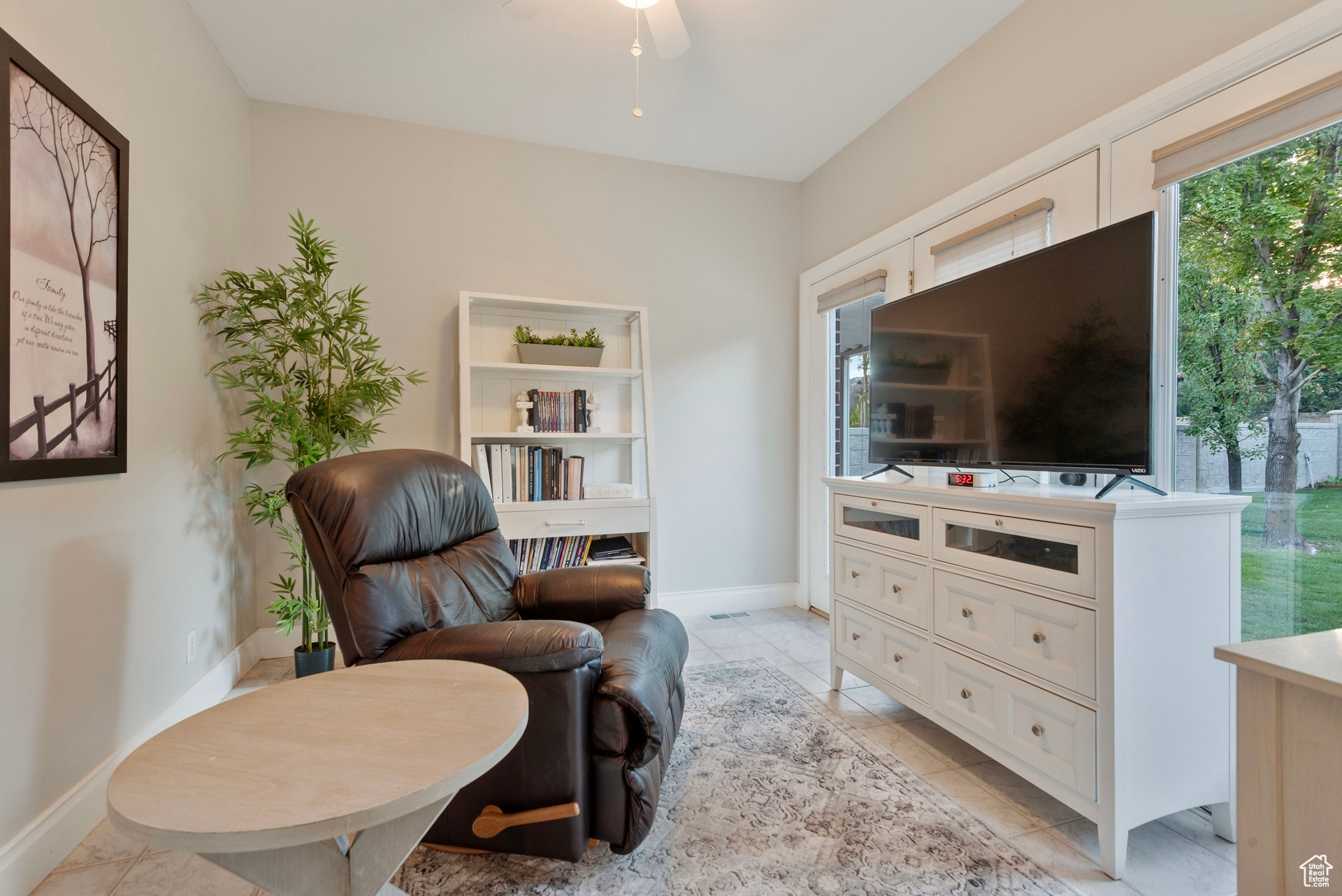 Living area featuring light tile patterned flooring and ceiling fan