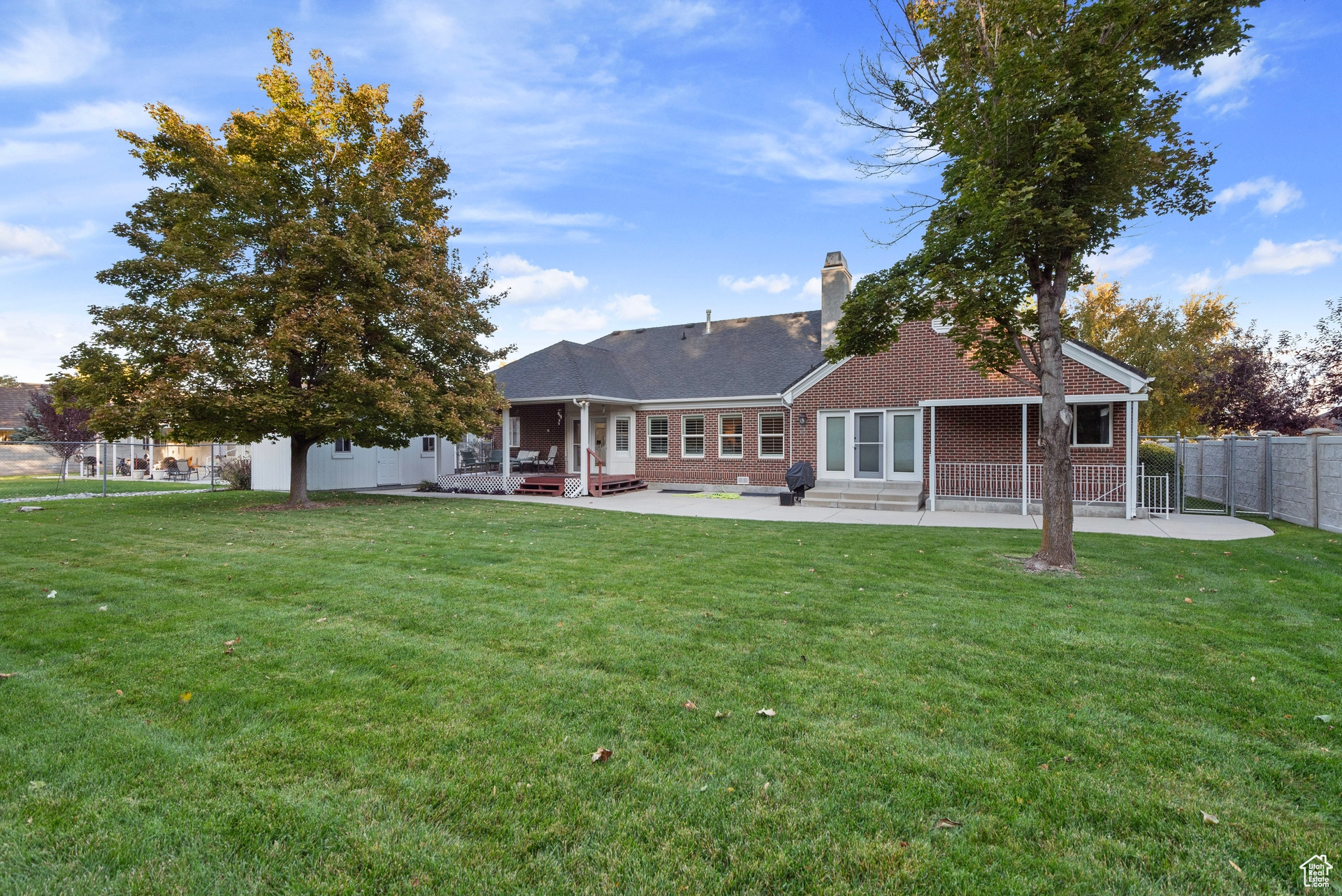 Rear view of house with a patio and a lawn