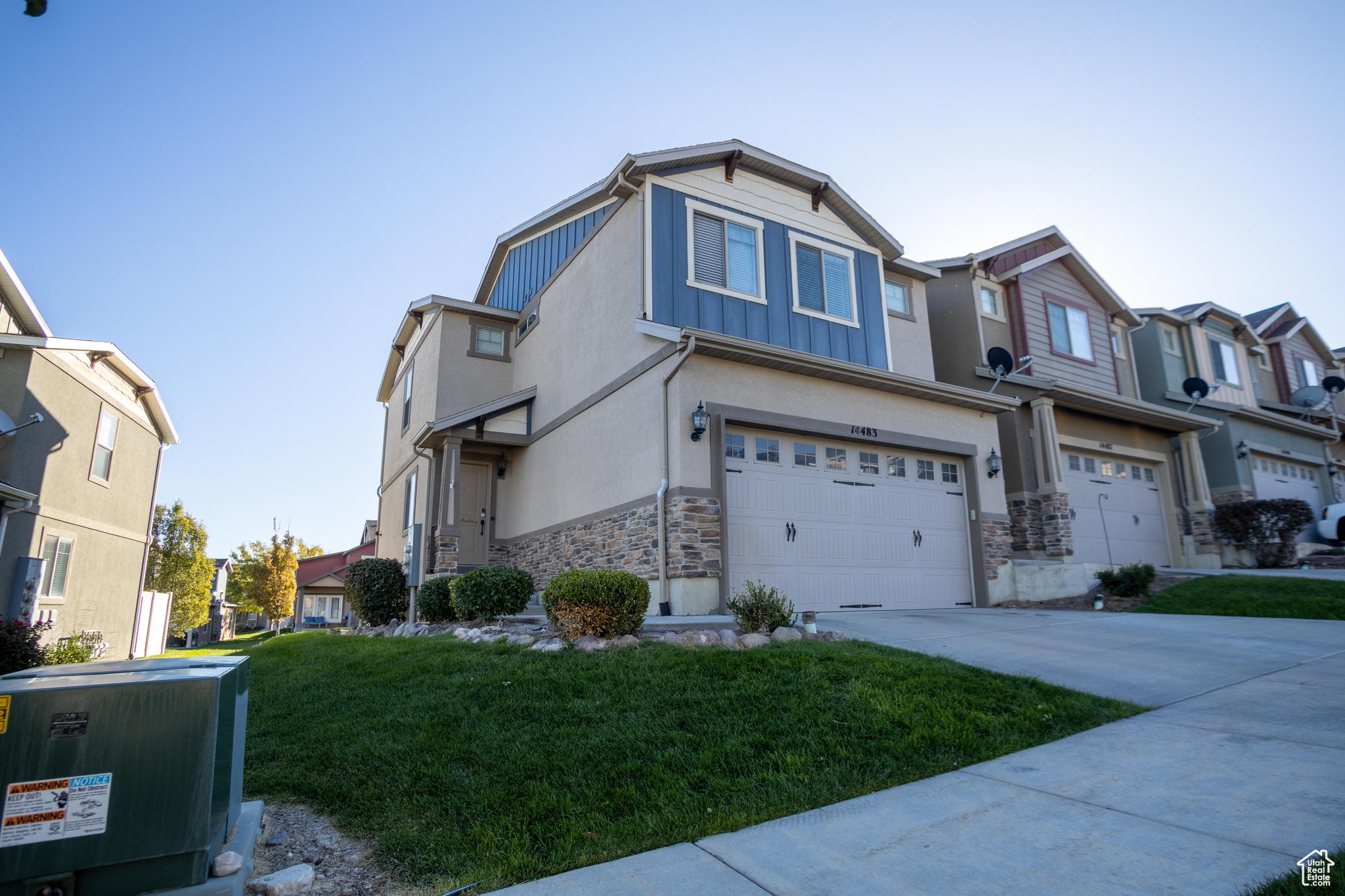 View of front facade featuring a front yard and a garage