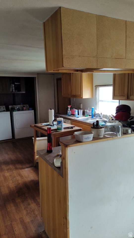 Kitchen featuring sink, separate washer and dryer, and dark hardwood / wood-style floors