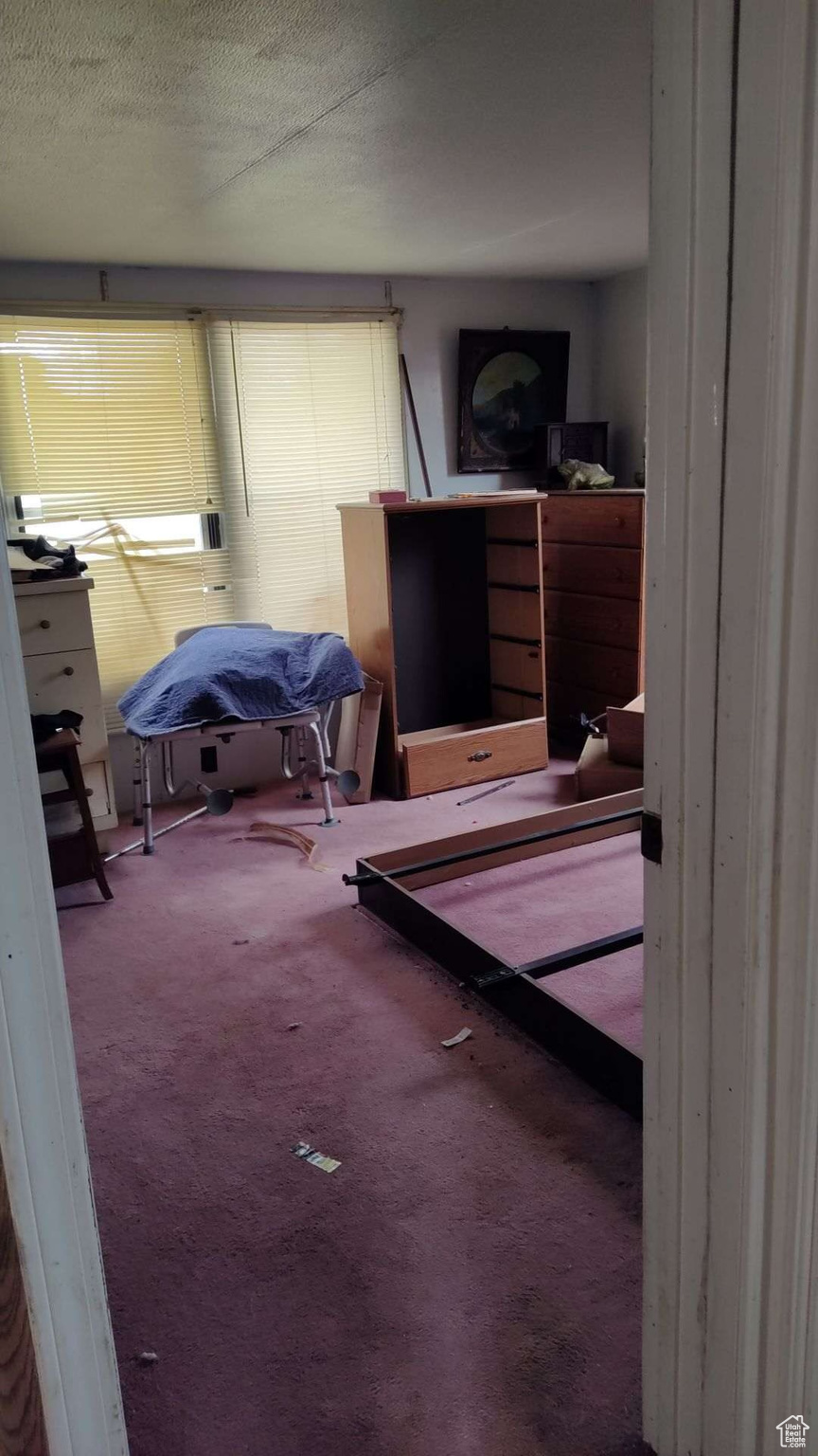 Bedroom featuring carpet and a textured ceiling