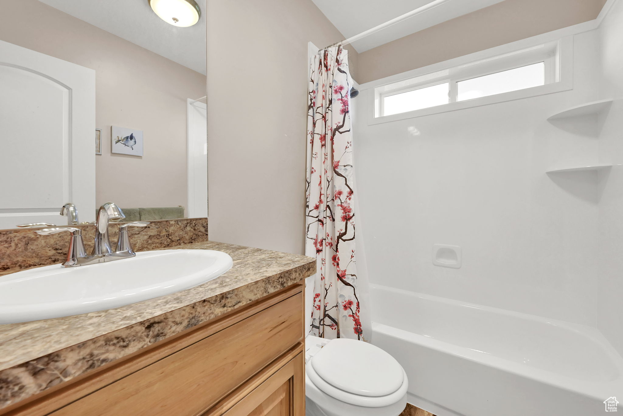 Full bathroom featuring toilet, vanity, and shower / bathtub combination with curtain