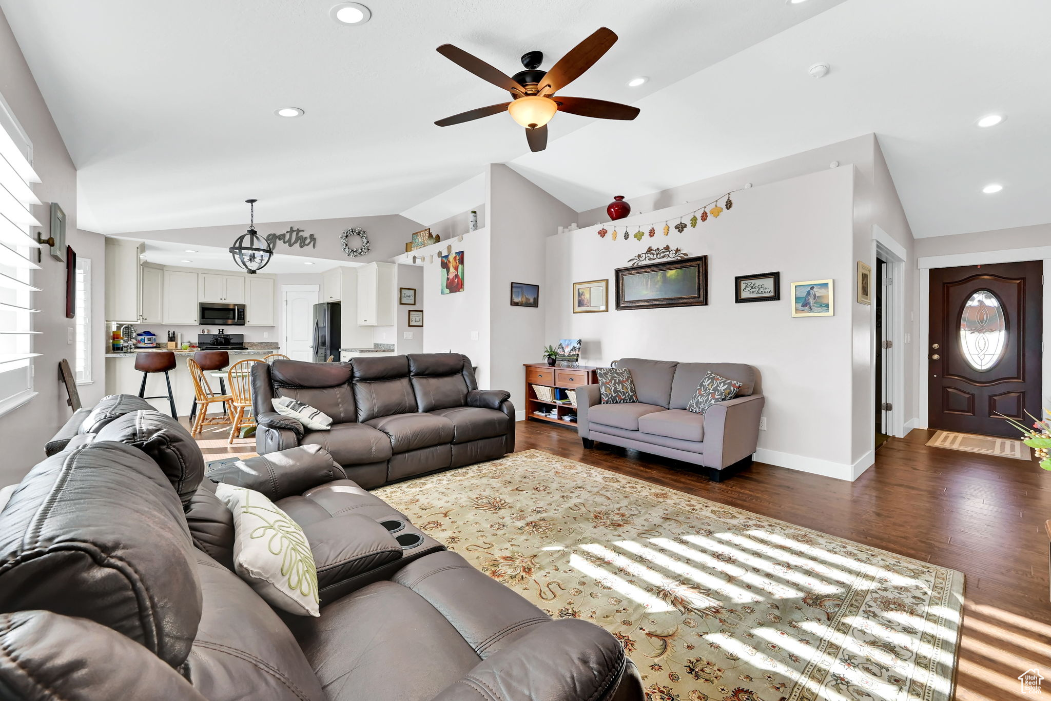 Living room with lofted ceiling, ceiling fan, and dark hardwood / wood-style flooring