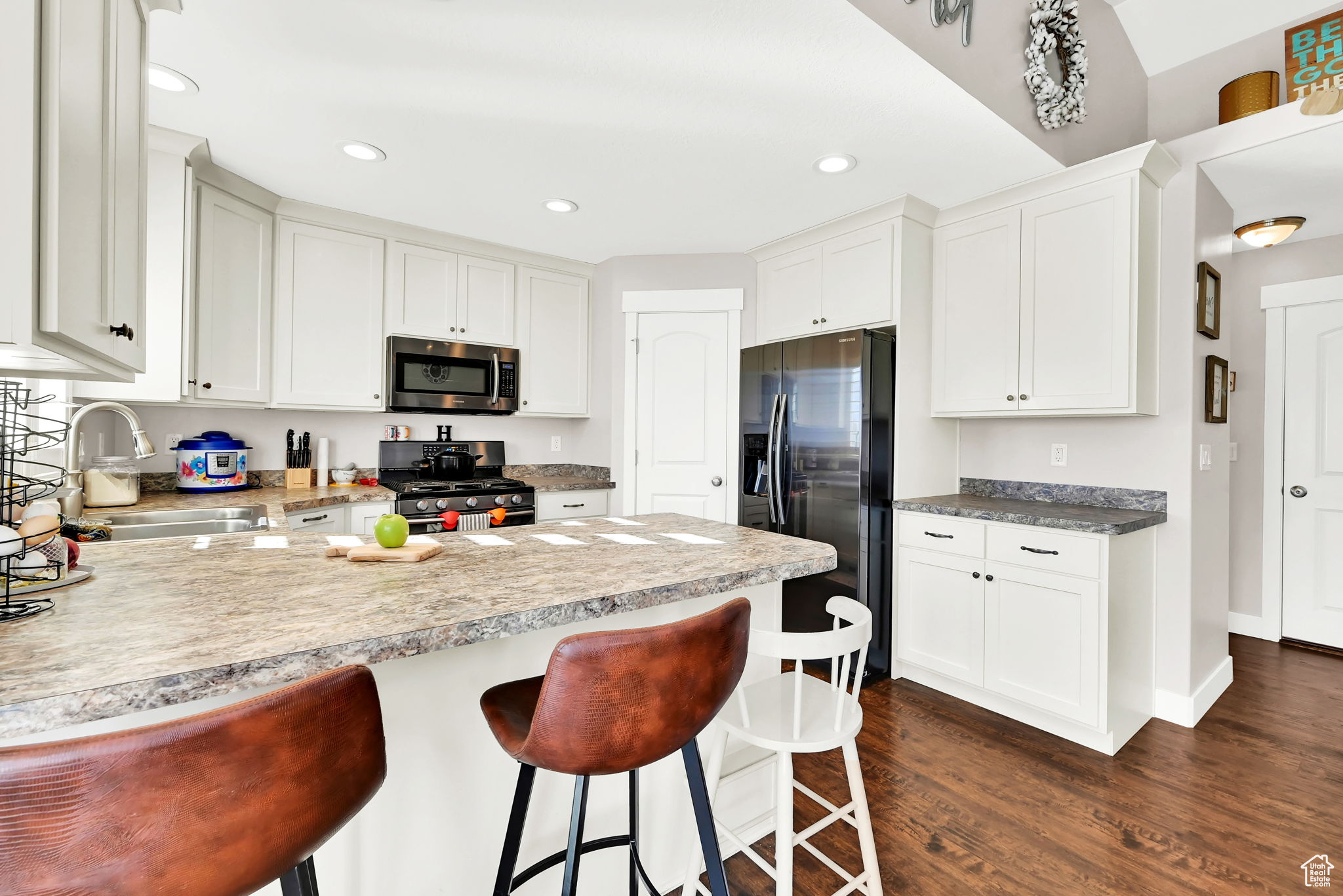 Kitchen featuring white cabinetry, dark hardwood / wood-style floors, stainless steel appliances, and sink