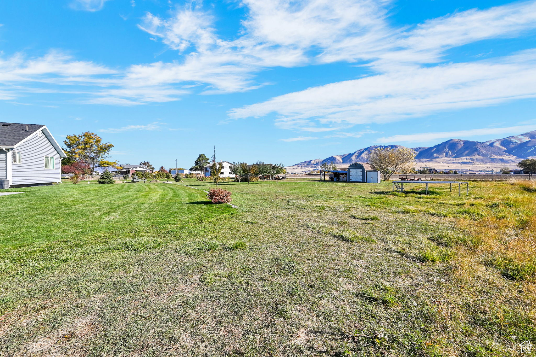 View of yard with a storage unit, a mountain view, and a rural view