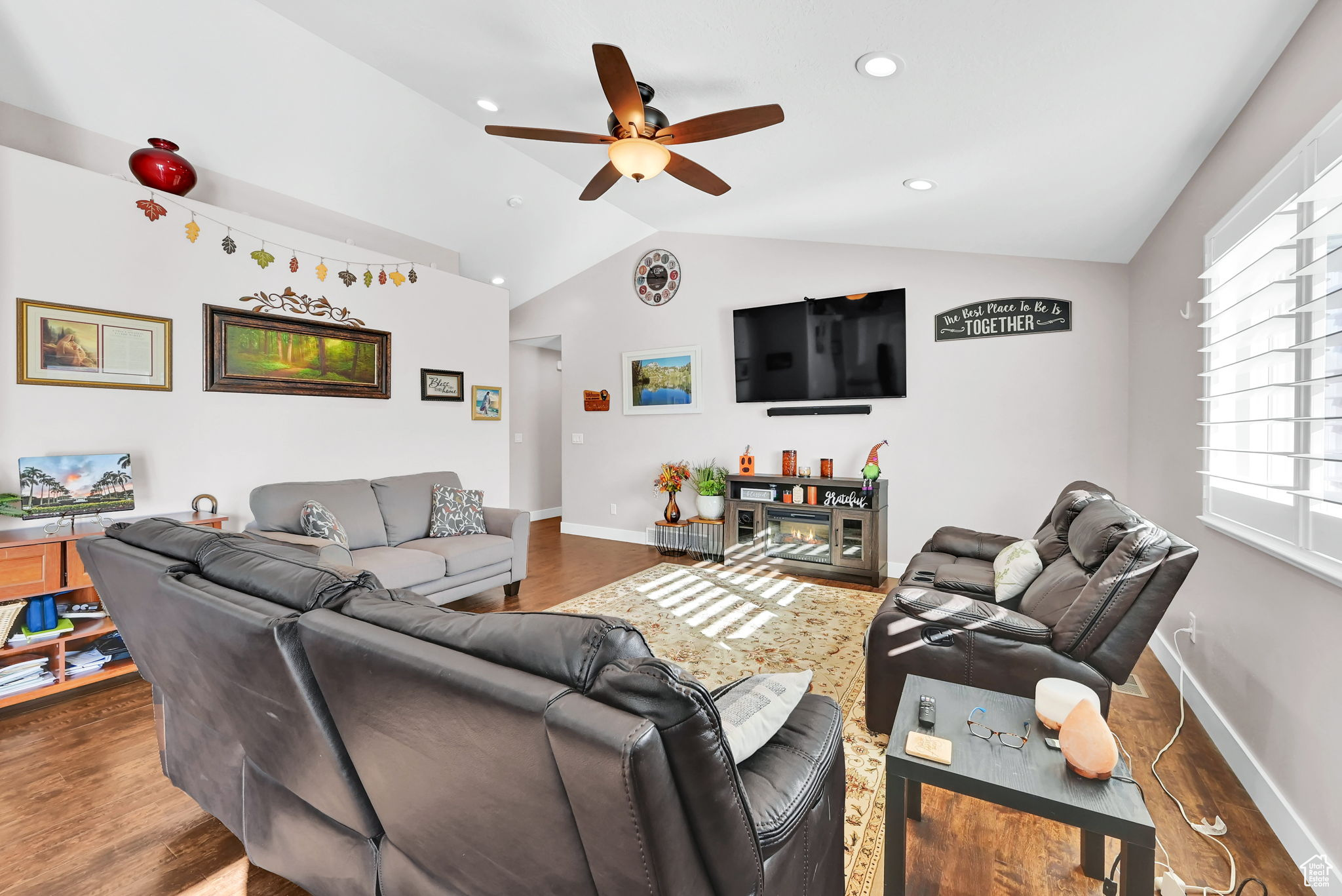 Living room featuring dark hardwood / wood-style floors, ceiling fan, and vaulted ceiling