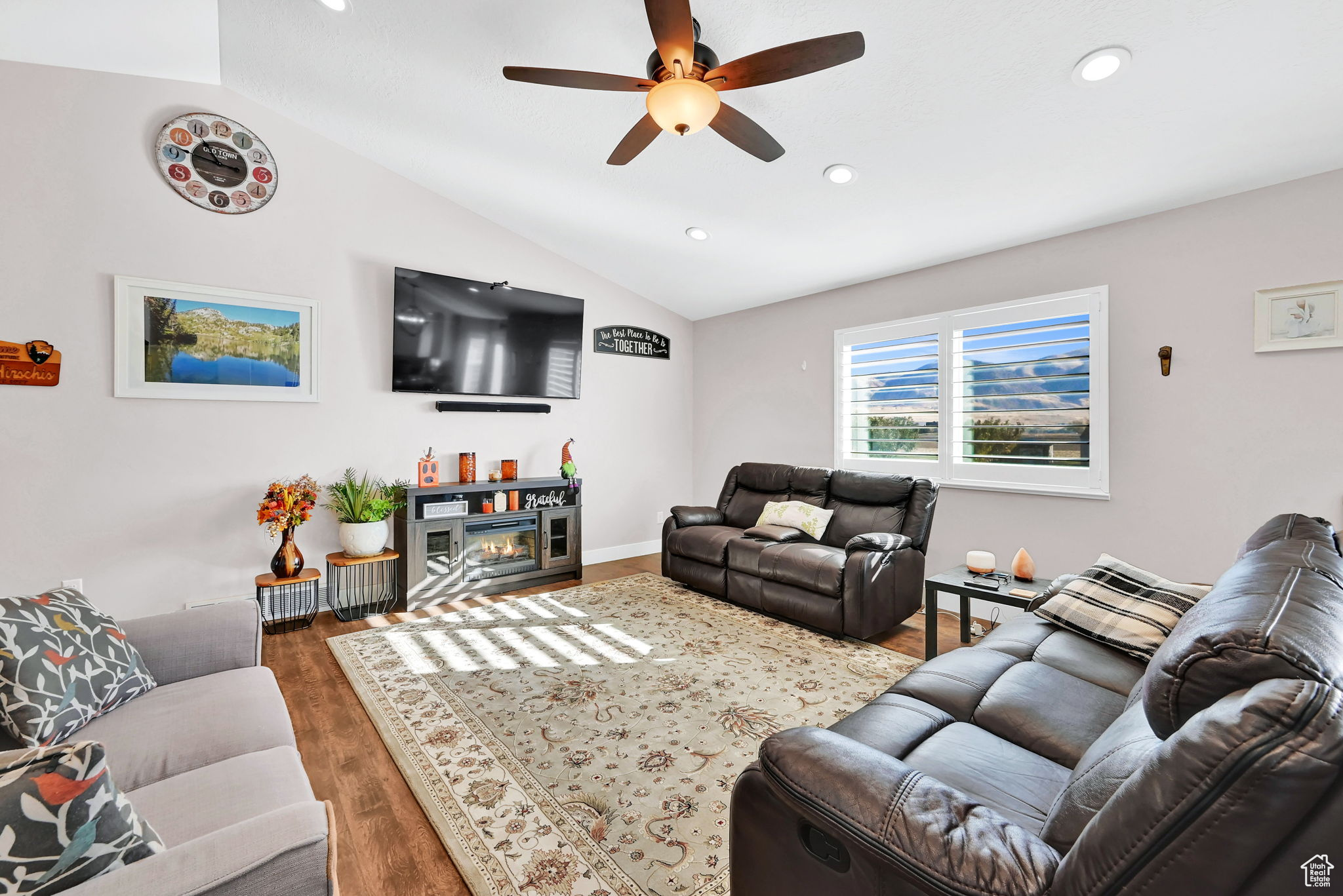 Living room featuring ceiling fan, lofted ceiling, and dark hardwood / wood-style floors