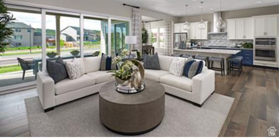 Living room featuring light hardwood / wood-style flooring. Photos are of a Decker plan but not the subject property.