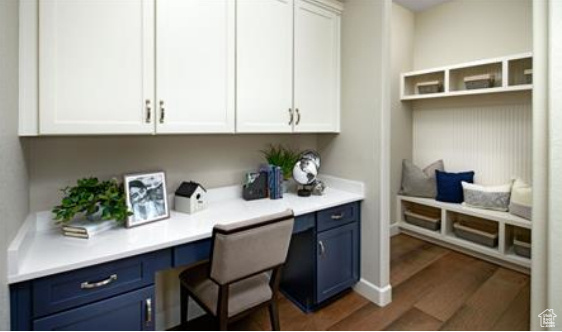 Office area featuring built in desk and dark wood-type flooring. Photos are of a Decker plan but not the subject property.